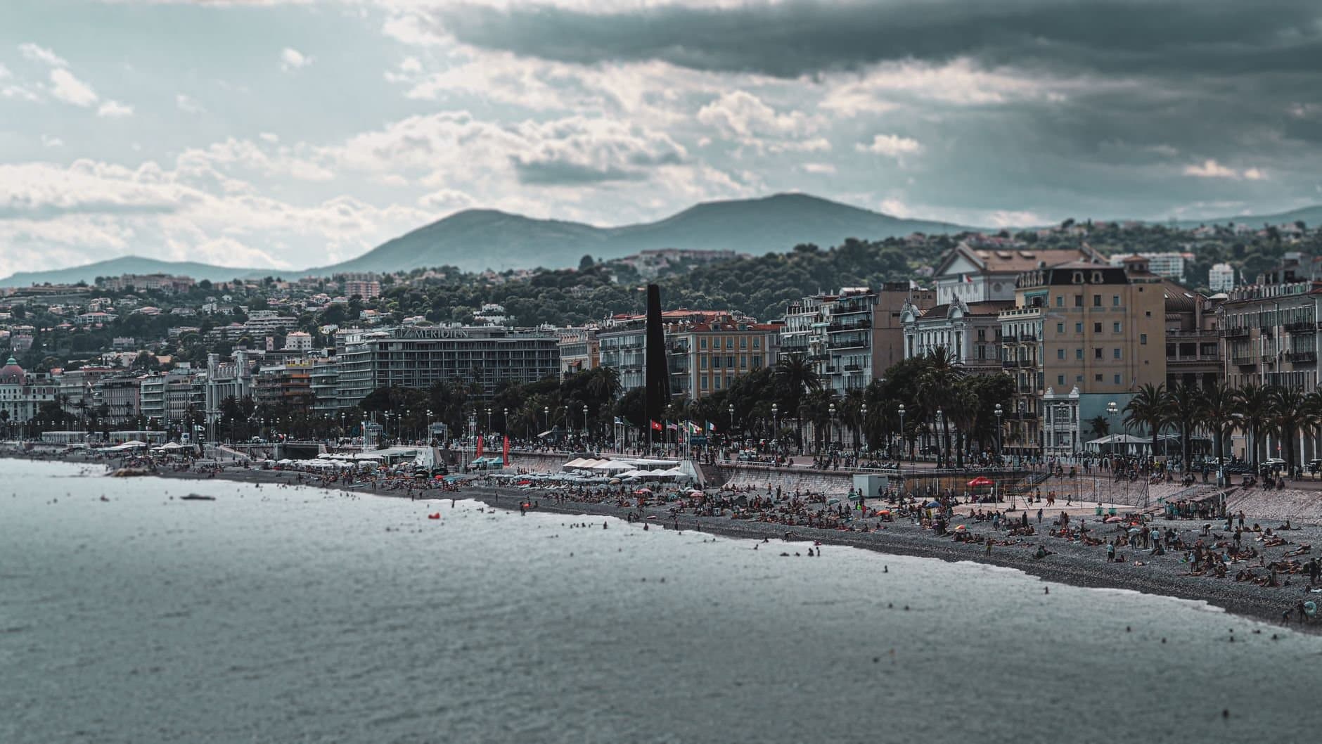A captivating view of a bustling beachfront city against a mountainous backdrop, capturing vibrant urban life.
