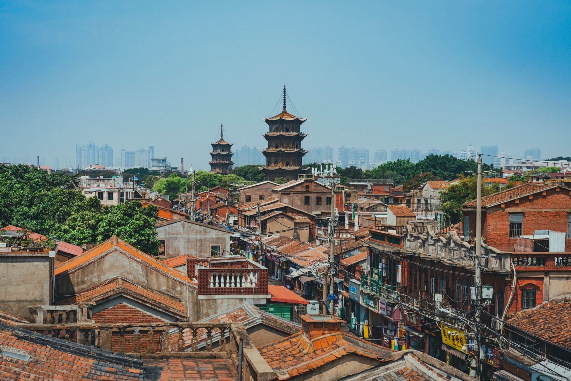 A scenic view of Quanzhou's traditional rooftops and iconic pagodas against a modern skyline.