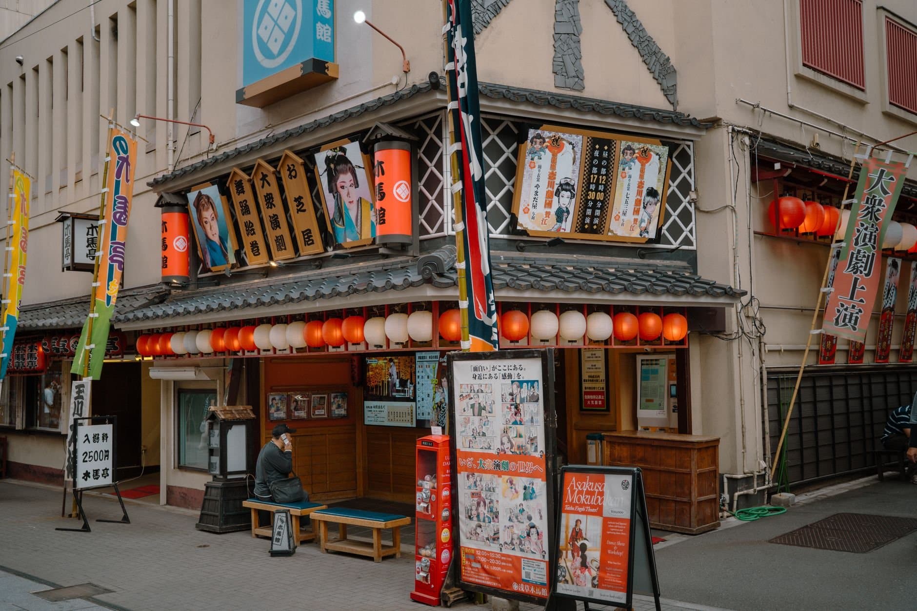 Street scene of a traditional theater façade with colorful banners and lanterns in Tokyo, Japan.