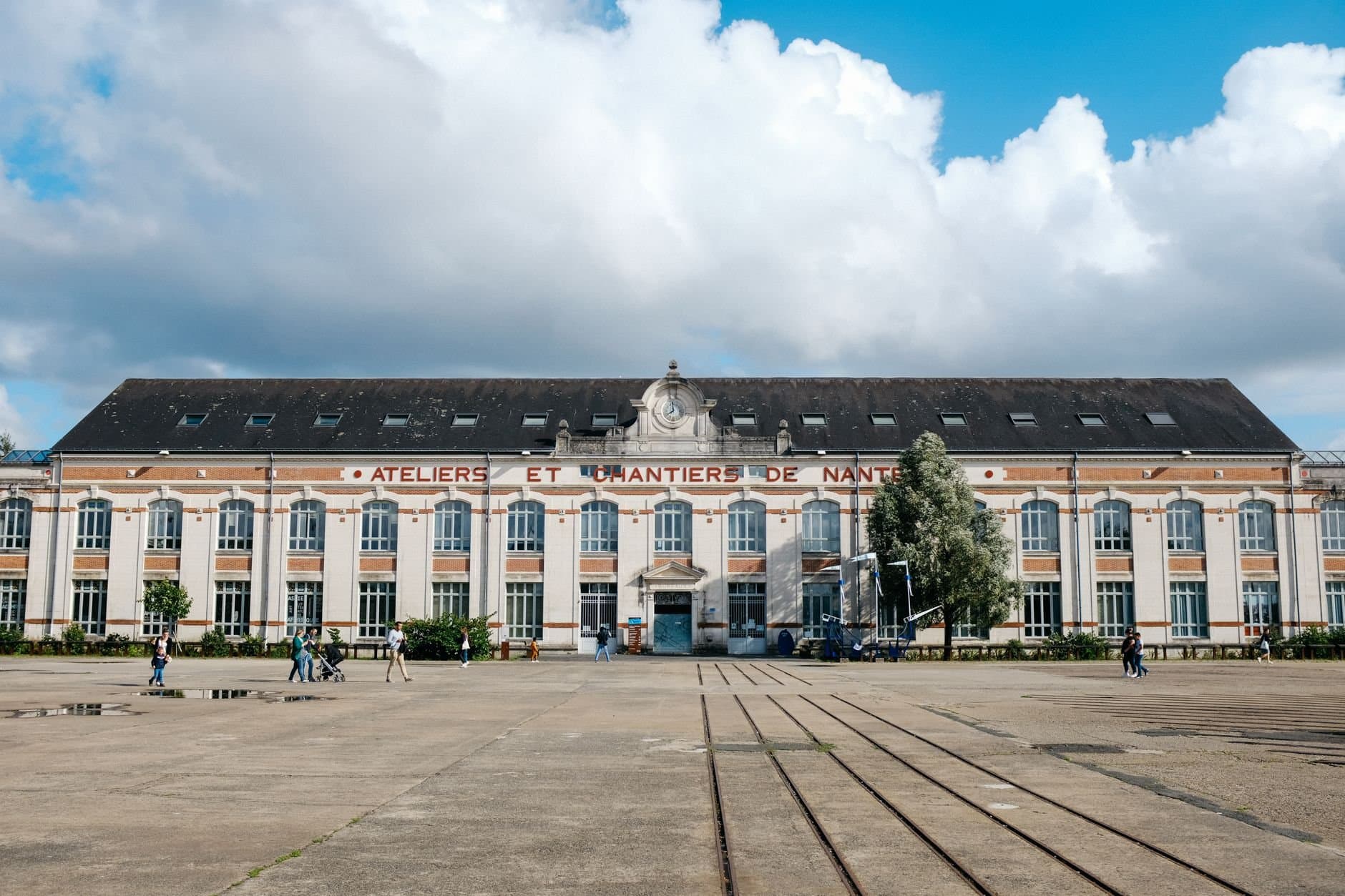 Front view of Ateliers et Chantiers de Nantes with cloudy sky.