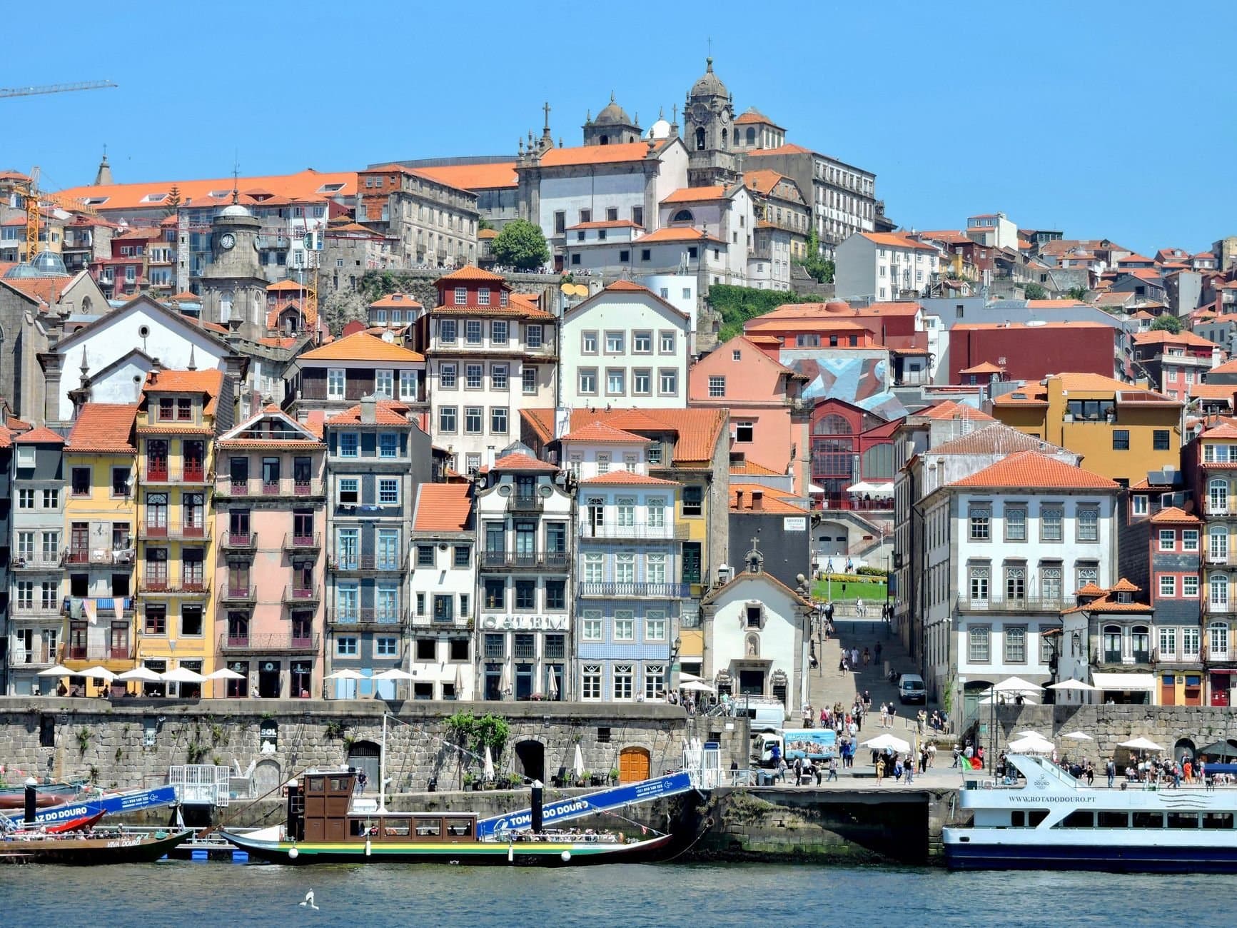 A vibrant view of the historic Ribeira District along the Douro River in Porto, Portugal.