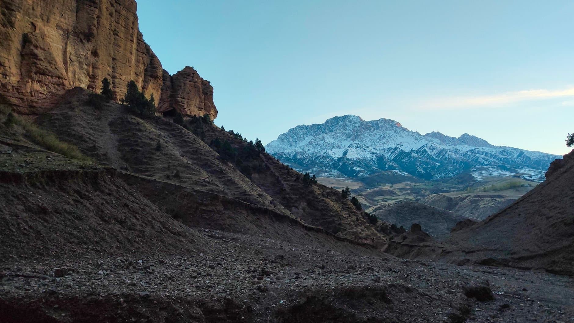 Scenic view of snow-capped mountains and rugged landscape in Osh Region, Kyrgyzstan.