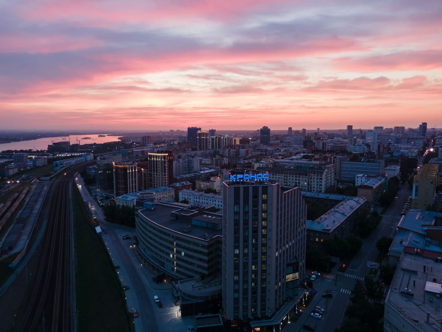 Stunning aerial view of Novosibirsk city skyline under a vibrant sunset sky.