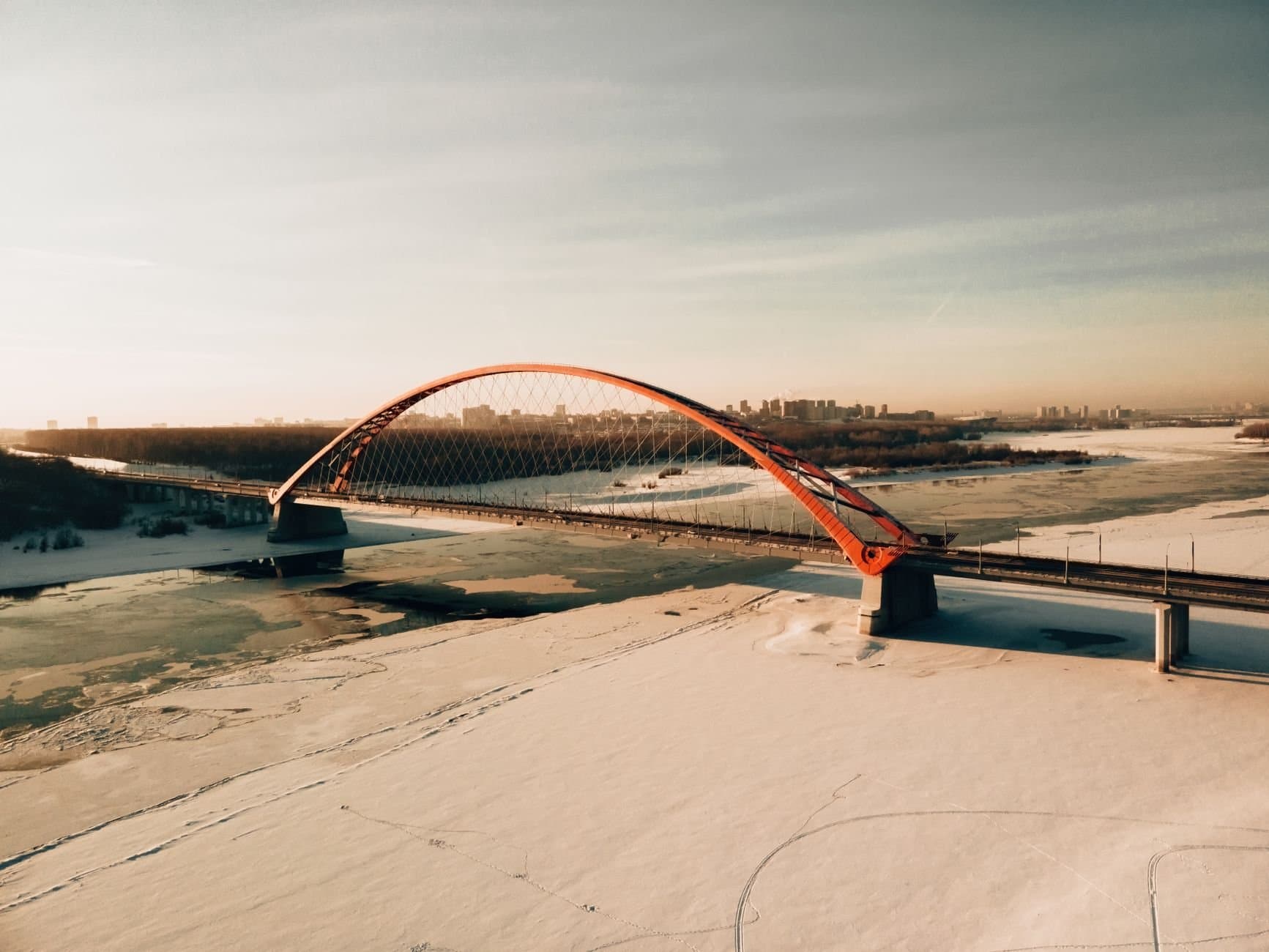 Stunning aerial view of Bugrinsky Bridge over frozen Ob River in winter, Novosibirsk, Russia.