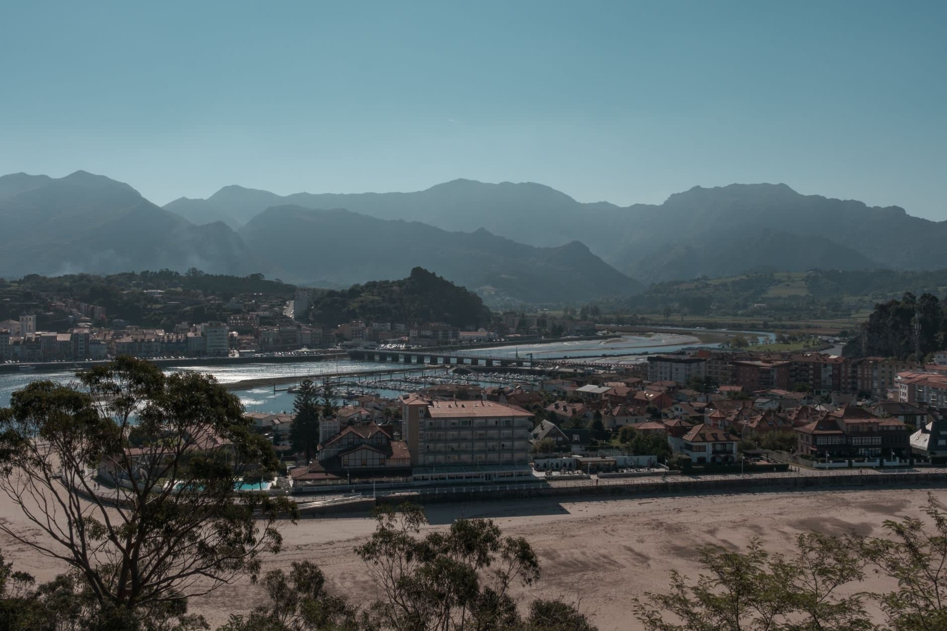 Scenic view of a coastal town in Asturias with mountains in the background, Spain.