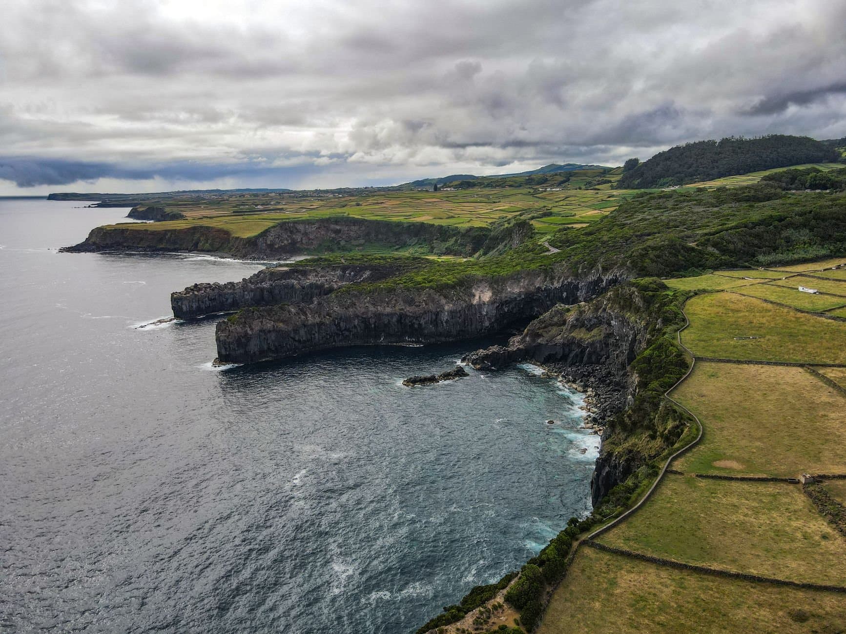 Aerial view of the dramatic coastal cliffs and lush landscapes of São Miguel Island, Azores.