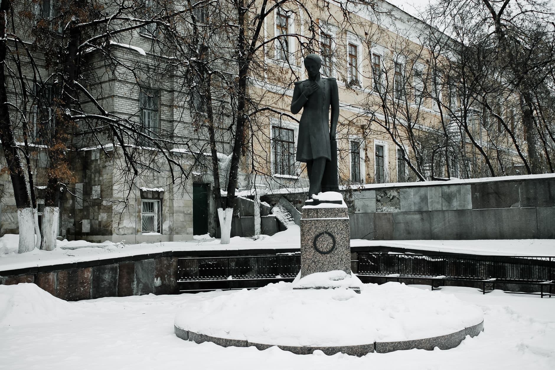 A statue stands in a snow-covered urban winter scene in Penza, Russia.