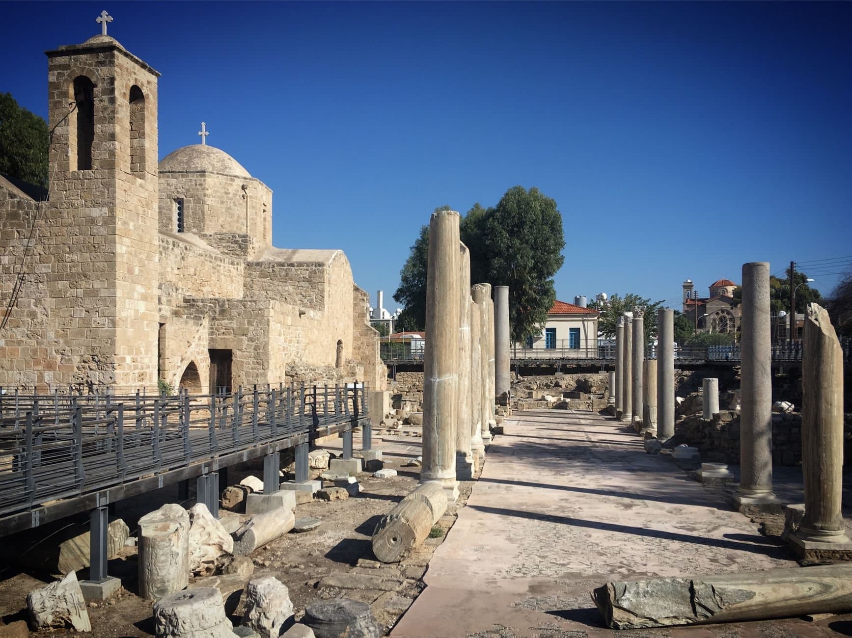 Explore the historic stone architecture and ancient ruins in Paphos, Cyprus, under clear blue skies.