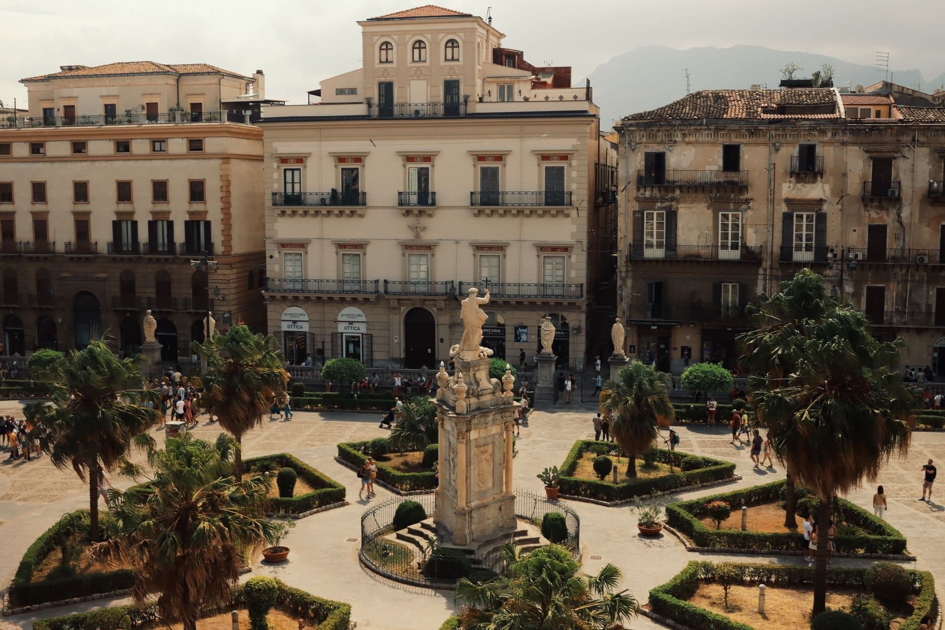 Aerial shot of a historic piazza in Palermo, Italy with landmarks and urban architecture.