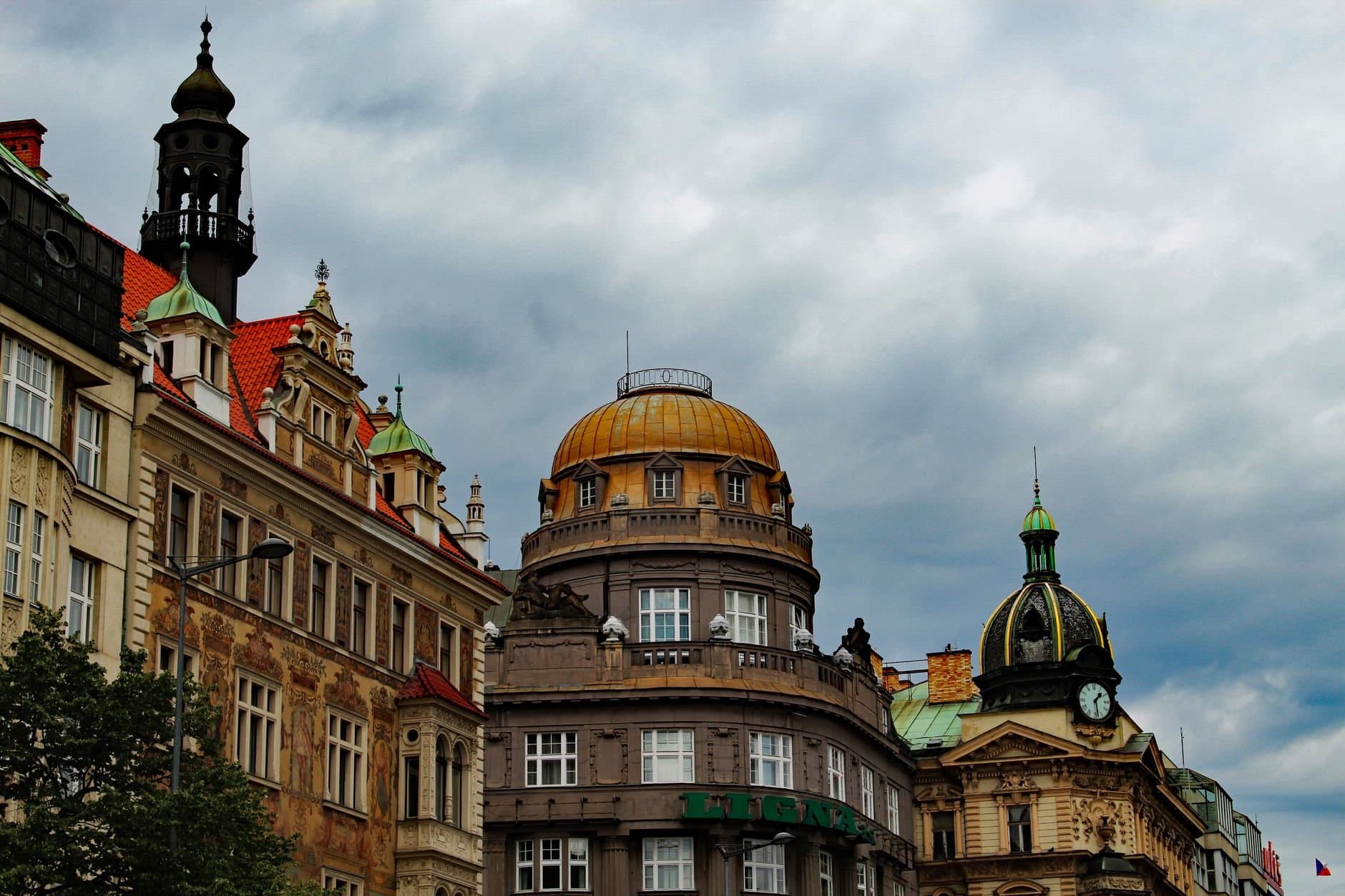 Dramatic view of historical buildings under a cloudy Prague sky in the city center.
