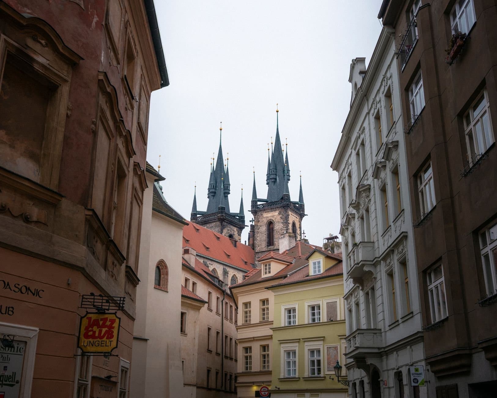 Captivating view of church spires in Prague's historic Old Town framed by traditional European architecture.