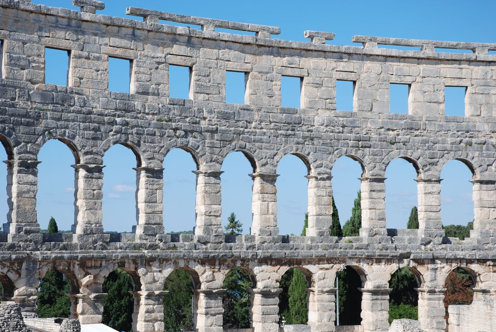 Stunning view of the ancient Roman amphitheater in Pula, Croatia against a clear blue sky.