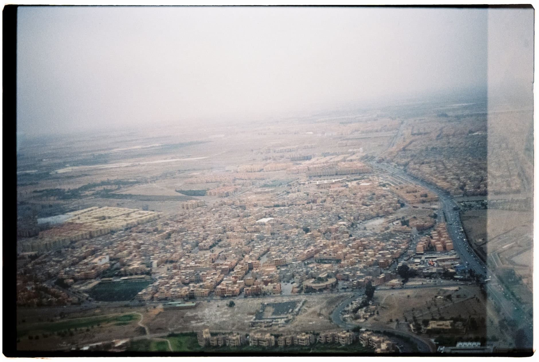 Aerial photograph of Marrakech cityscape enveloped in foggy atmosphere.