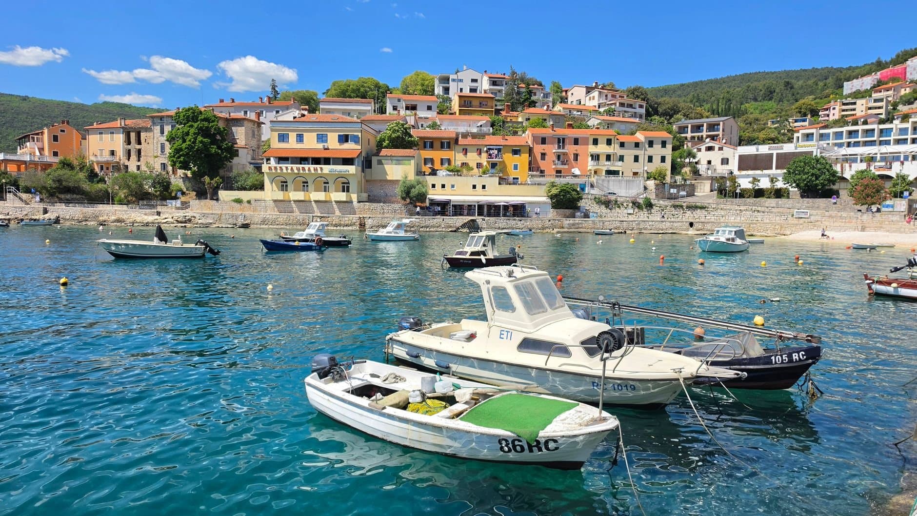A picturesque view of boats in a vibrant coastal town under a clear blue sky.