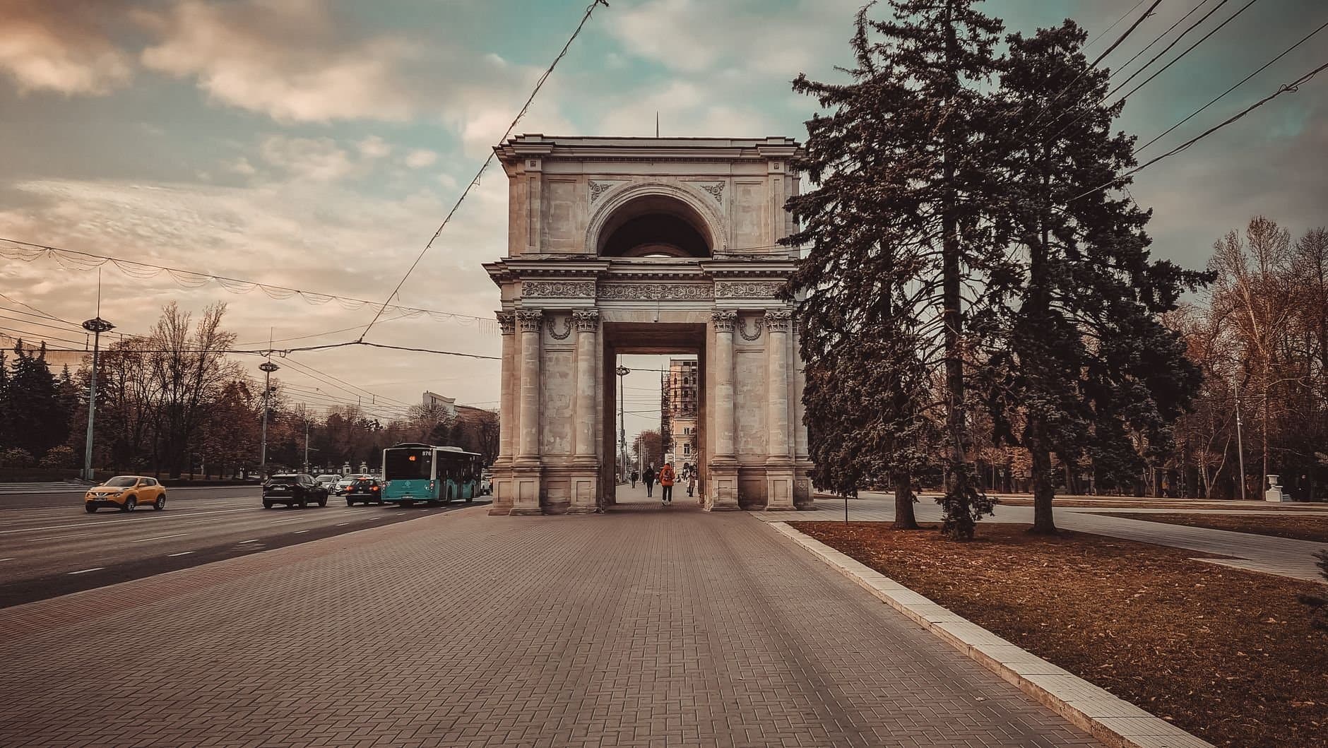 Historic Triumphal Arch in Chișinău, Moldova. A picturesque monument surrounded by a city street scene.