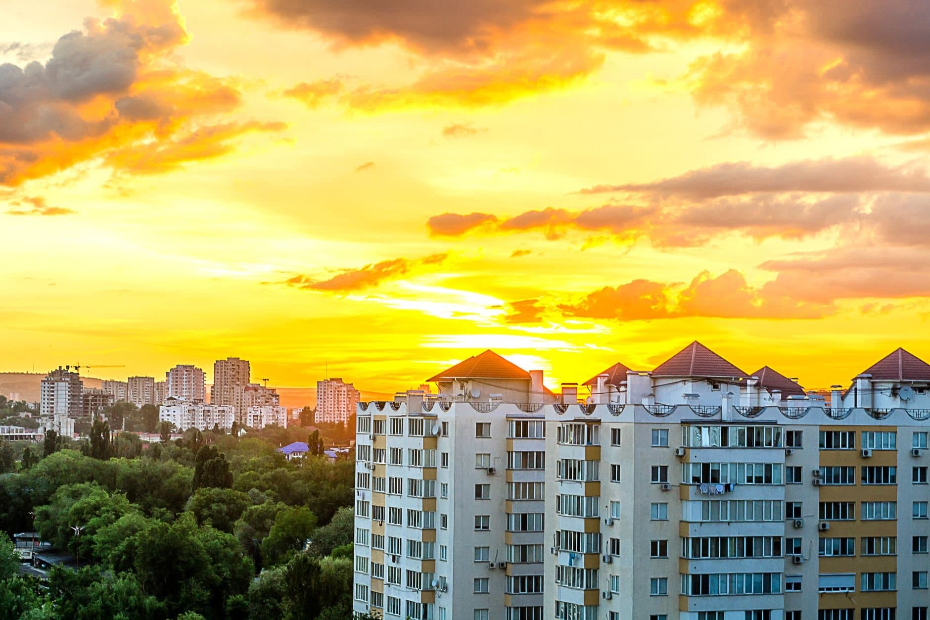 Stunning sunset over Chișinău cityscape with modern high-rise buildings.