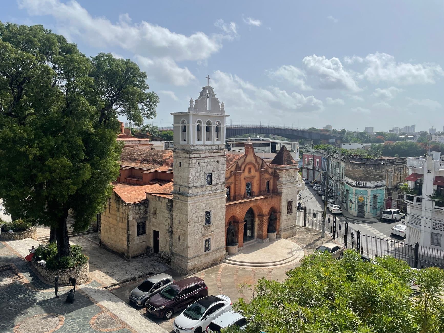 Aerial view of a historic colonial church in Santo Domingo under a bright day.