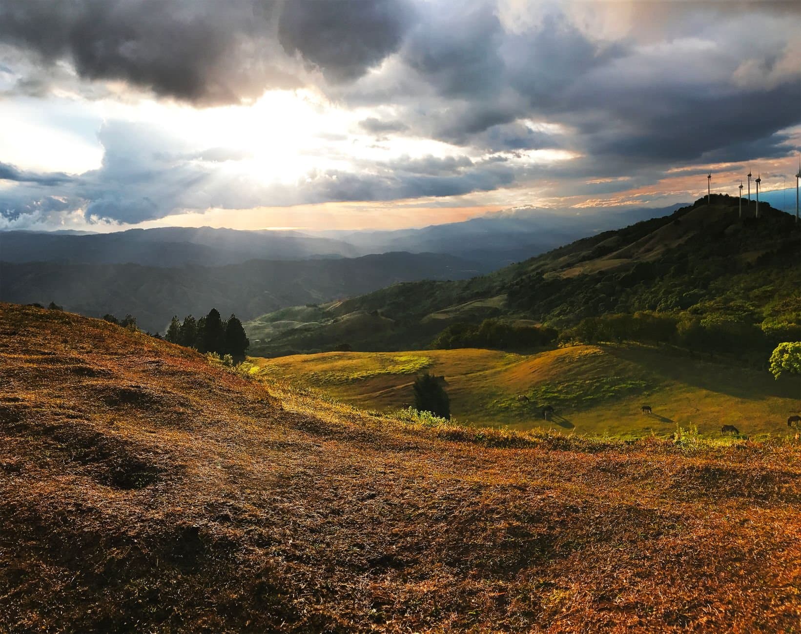 Stunning sunset landscape in San José, Costa Rica, with rolling hills and dramatic clouds.