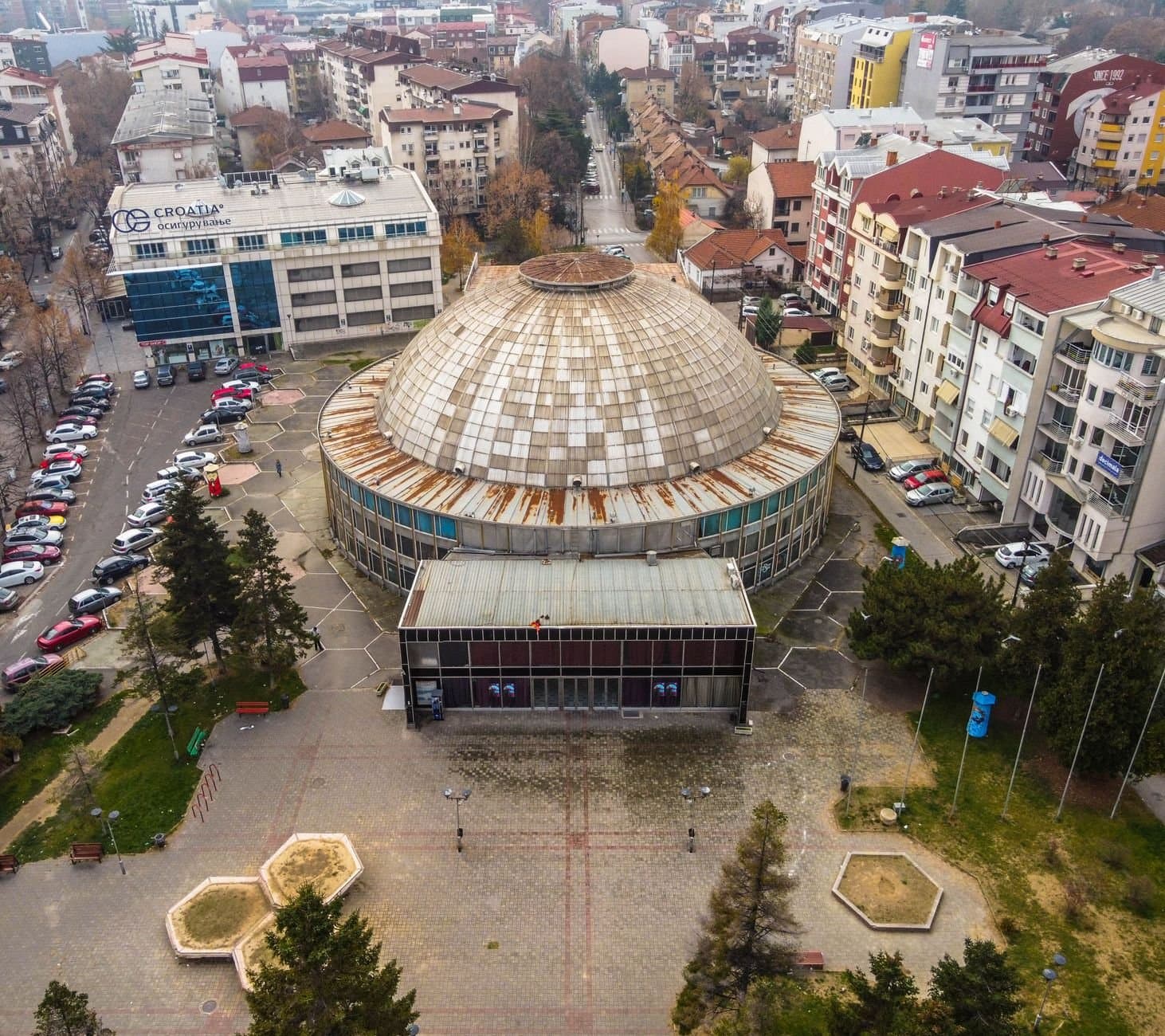 Aerial view of a dome building in Skopje's urban landscape.