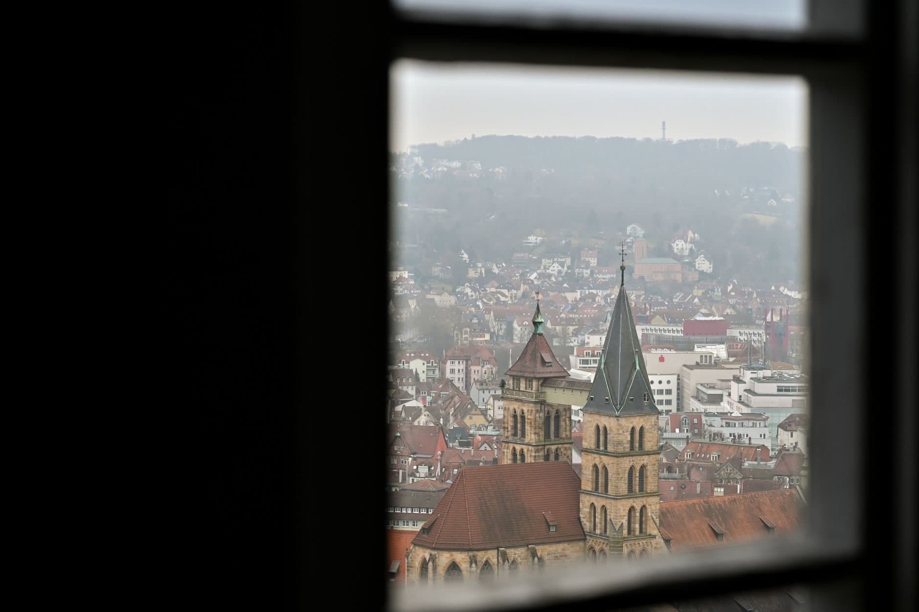 Cityscape of Stuttgart viewed through a window with a focus on historical architecture.