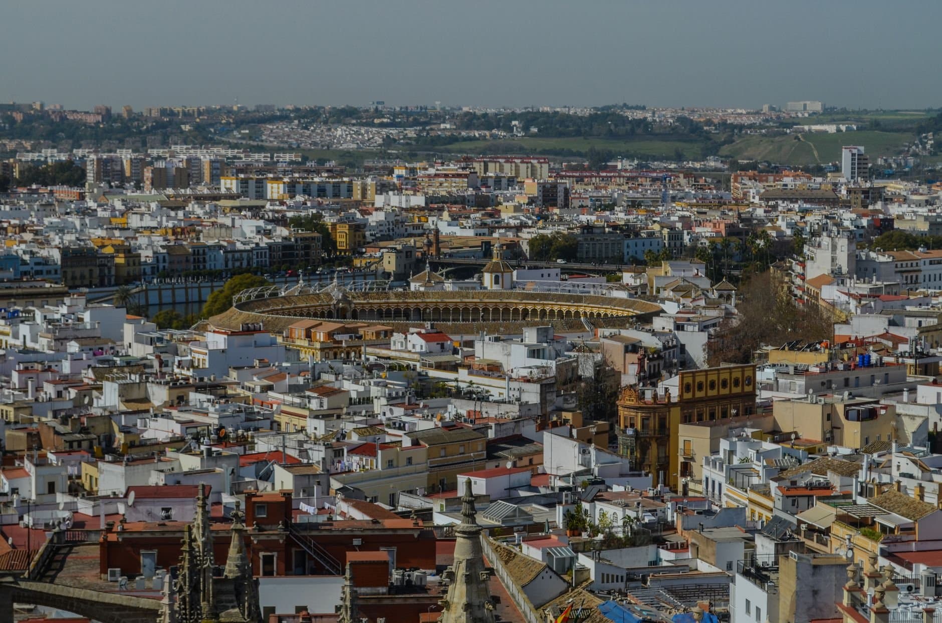 A stunning aerial view of Seville showcasing the iconic bullring and surrounding historic architecture.