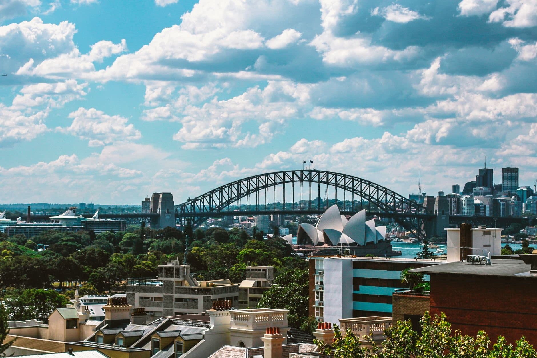 Stunning view of Sydney Harbour Bridge and Sydney Opera House on a sunny day, showcasing the vibrant cityscape.