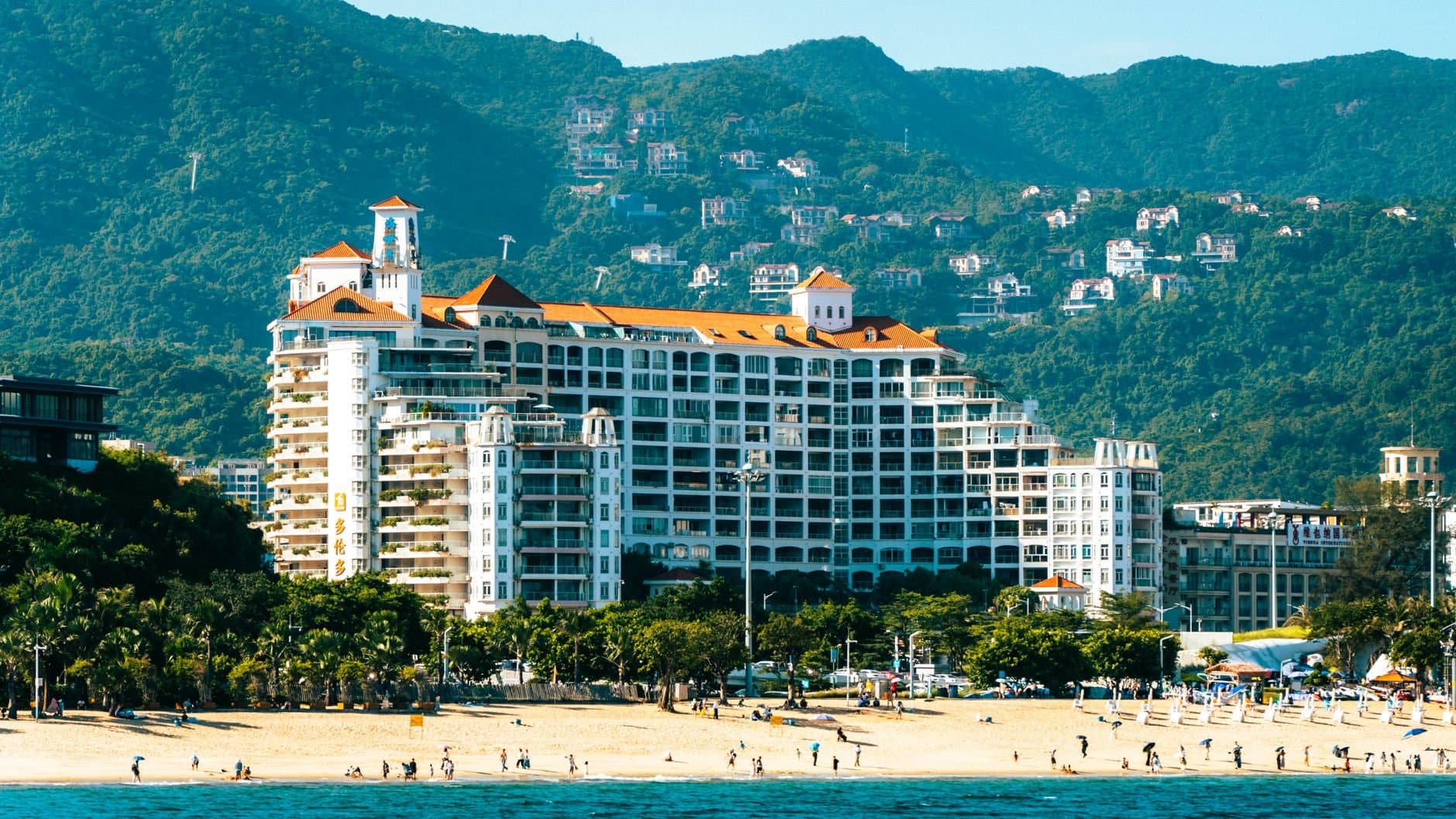 Beautiful beachfront resort with mountain backdrop, capturing coastal luxury and nature.