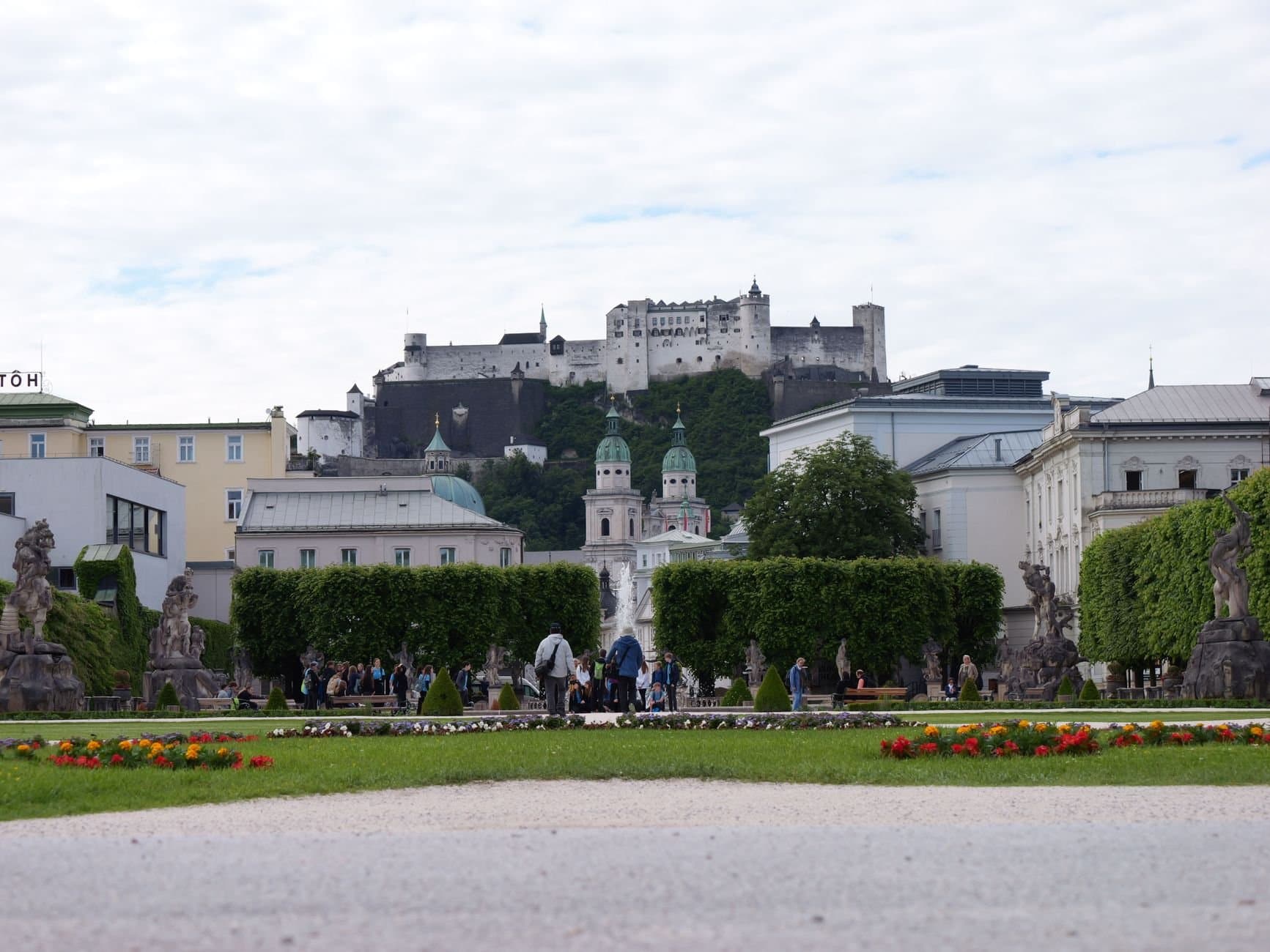 View of Hohensalzburg Castle from Mirabell Gardens in Salzburg. A blend of historical architecture and nature.