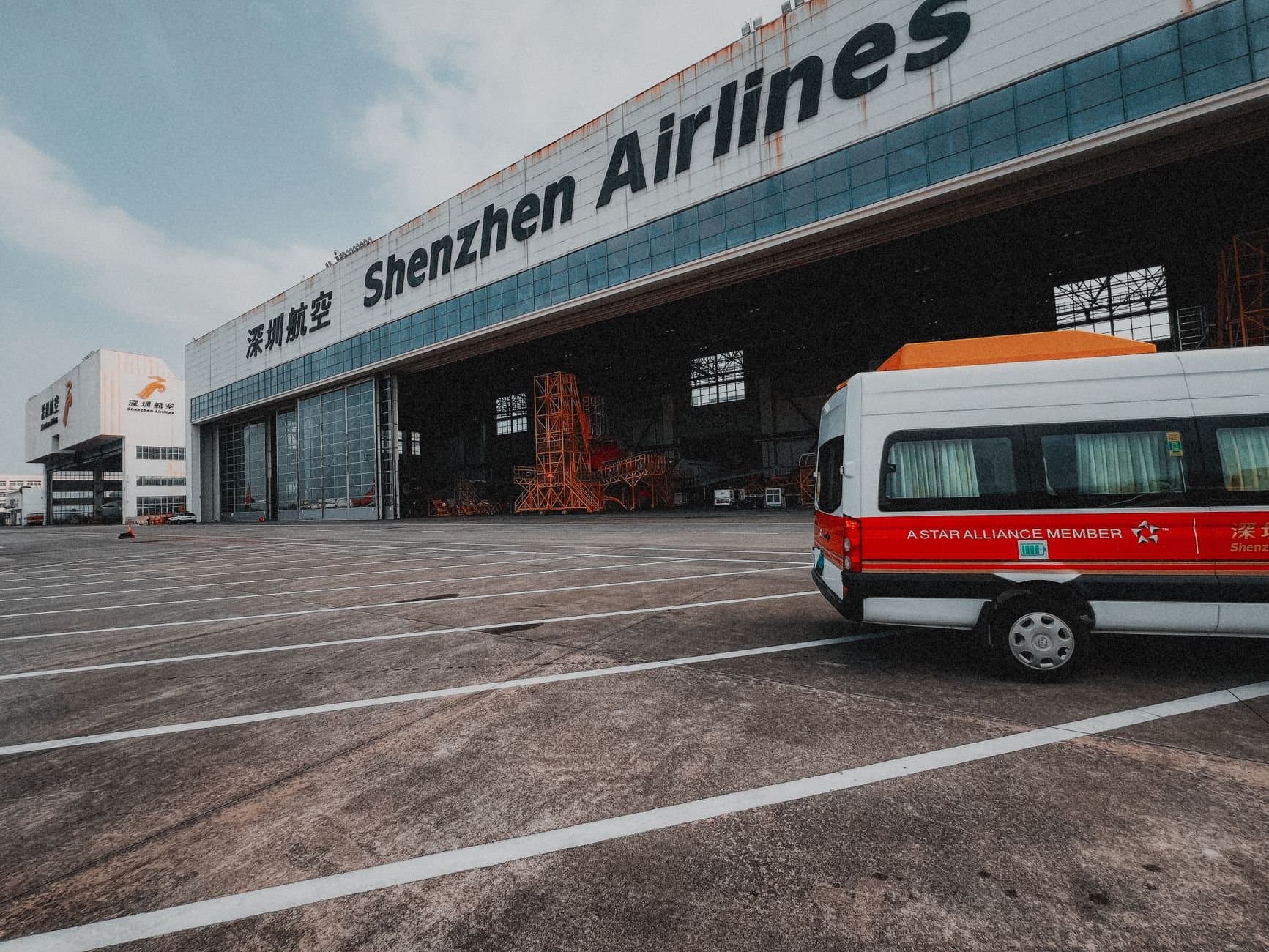 Shenzhen Airlines hangar with a parked van depicting air travel infrastructure.