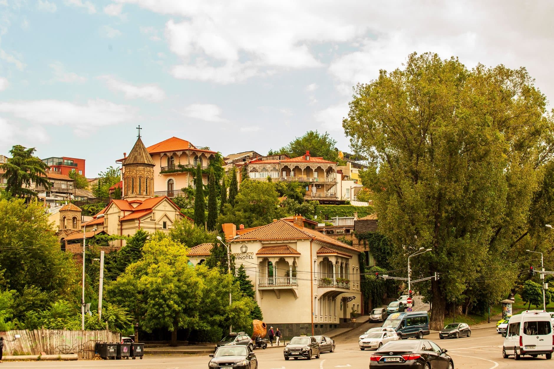 Scenic view of historical architecture and lush greenery in Tbilisi, Georgia.