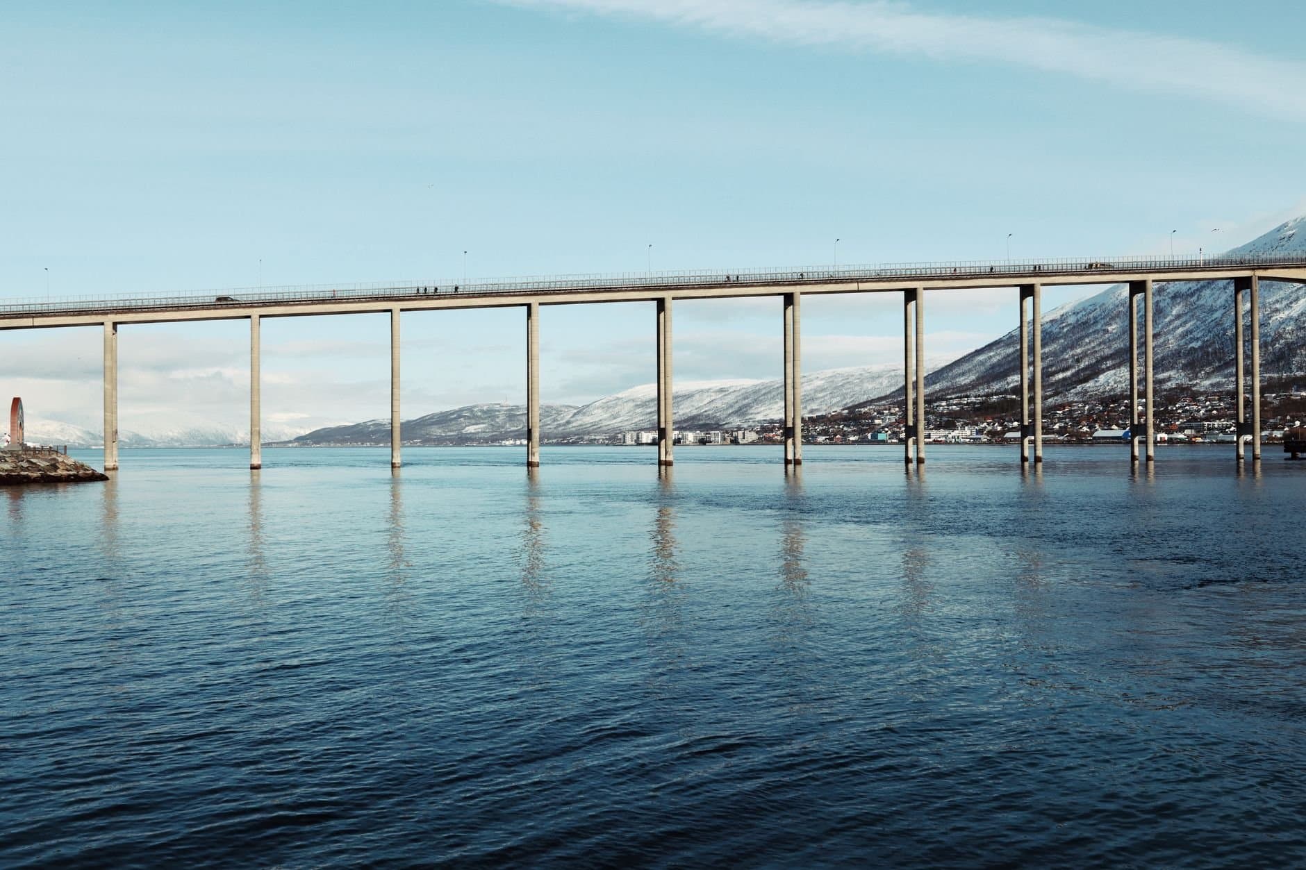 A breathtaking view of the Tromsø Bridge over calm Arctic waters in Norway.