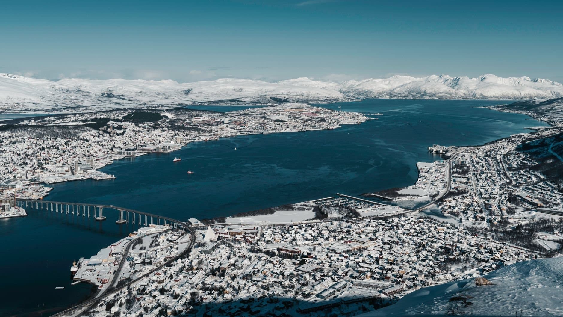 A breathtaking aerial view of Tromsø, Norway, showcasing its snowy landscape and scenic fjord.