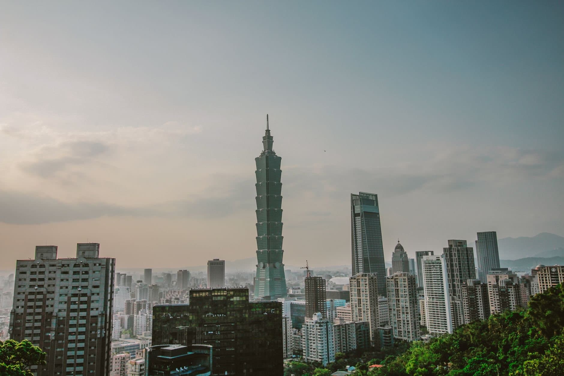 A scenic view of Taipei's skyline featuring the iconic Taipei 101 tower on a clear day.