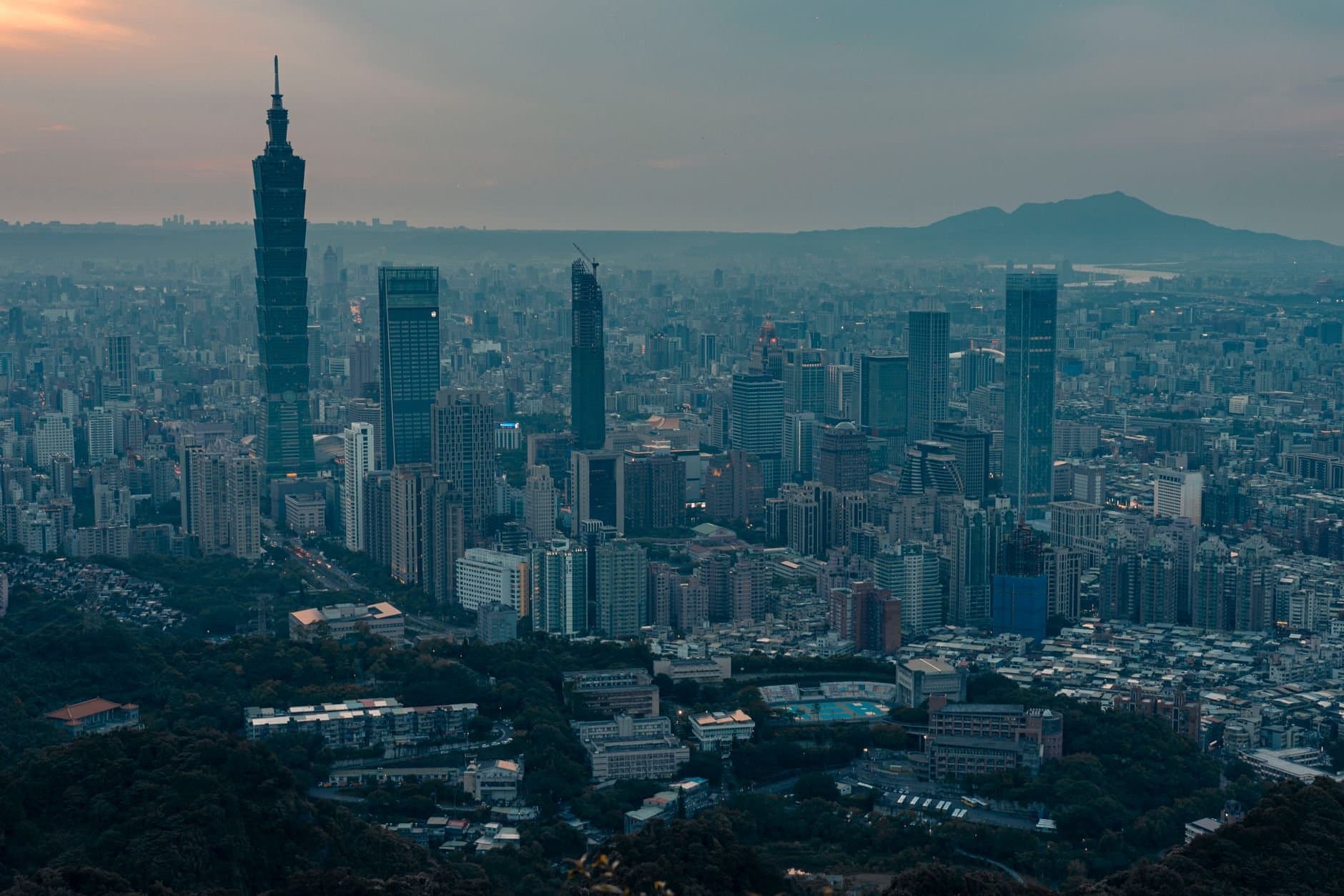 Dramatic aerial view of Taipei city skyline with Taipei 101 during twilight.