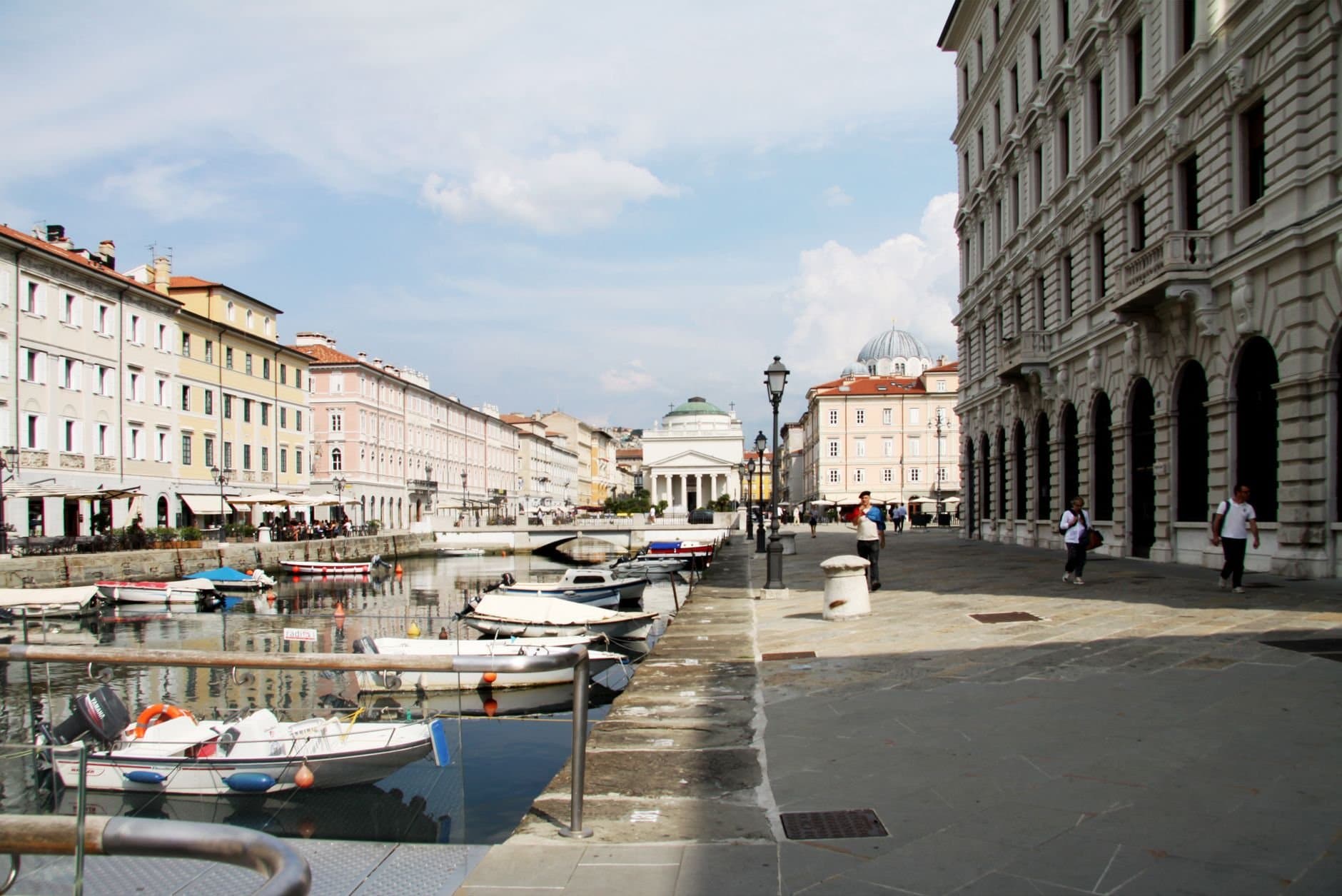 Scenic view of boats on a canal flanked by classic urban architecture and clear sky.