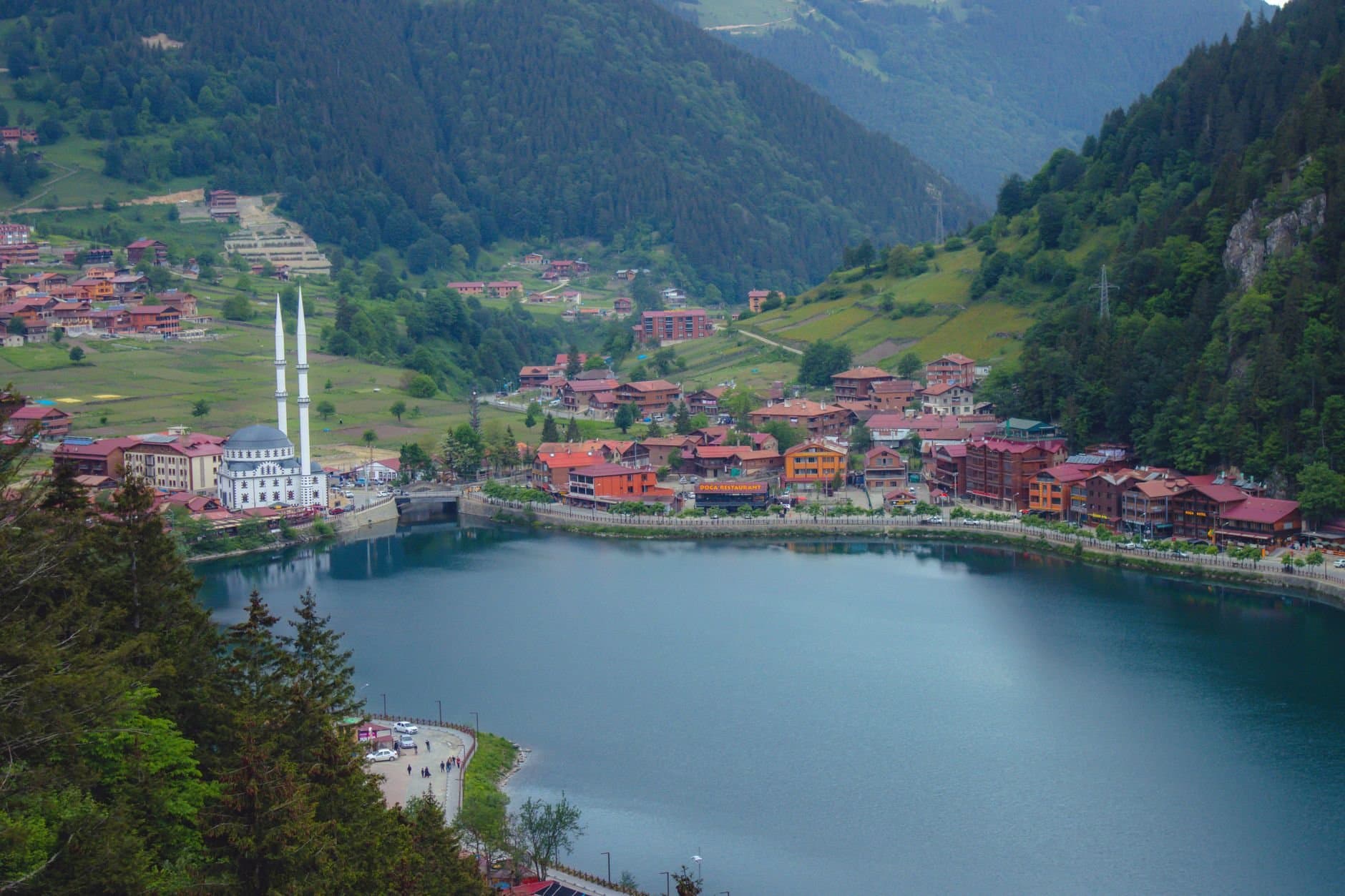 Scenic view of Uzungöl village by the lake with lush green mountains in Trabzon, Turkey.