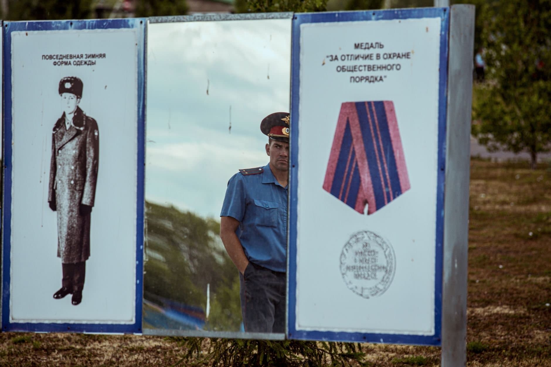A policeman reflects in a mirror displaying Soviet military designs and medals in Ufa, Russia.