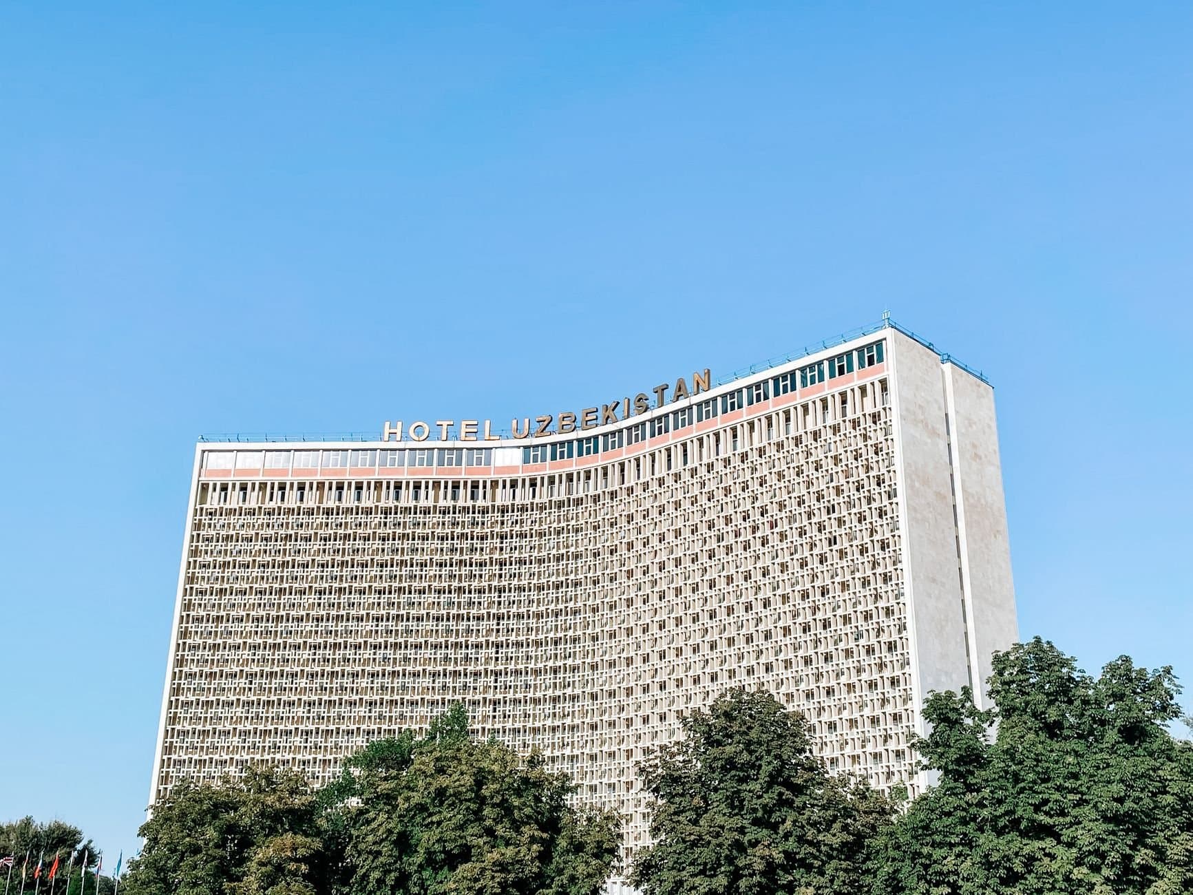 A striking view of the Hotel Uzbekistan facade under a clear blue sky.