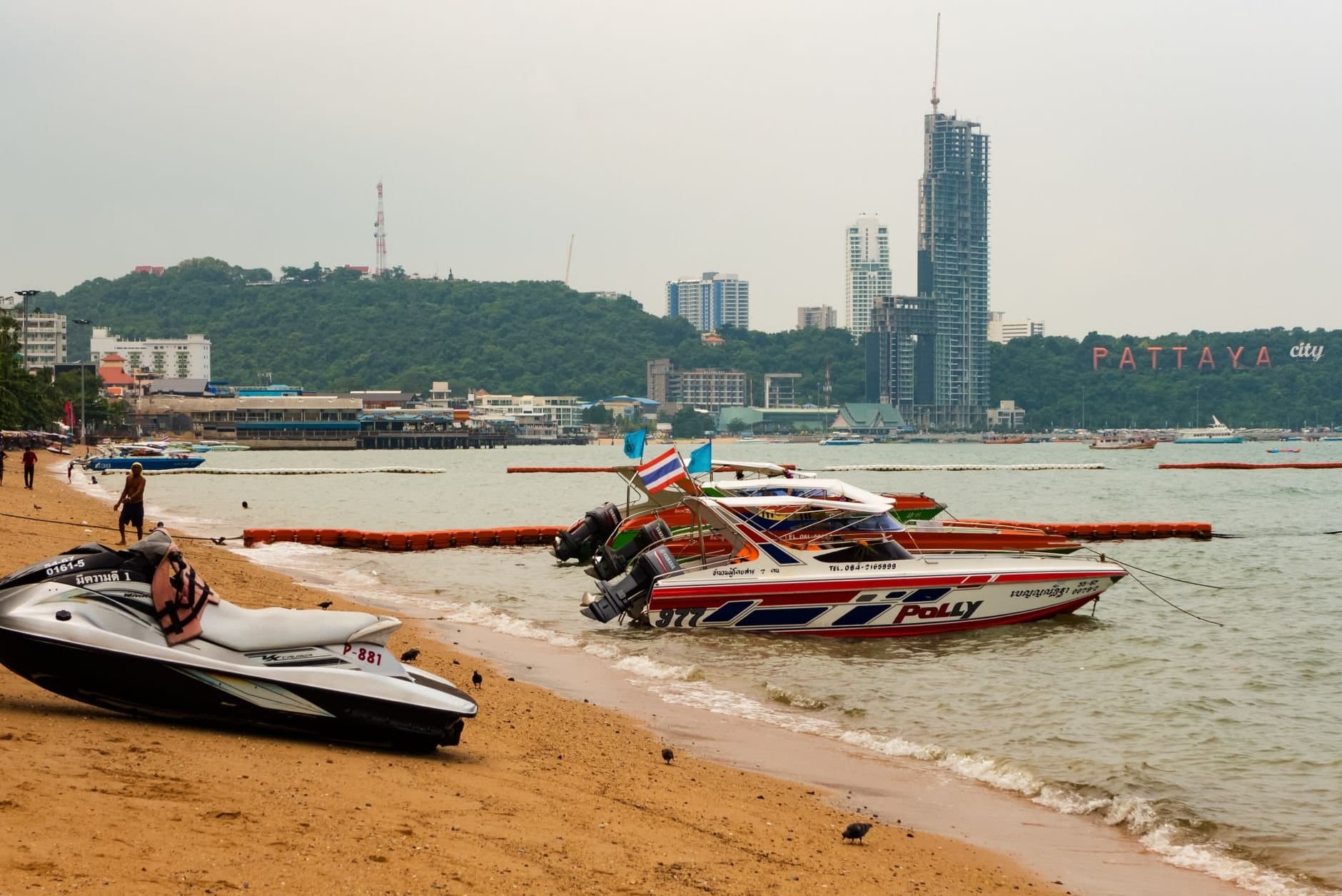 Explore the bustling Pattaya beach in Thailand, showcasing lively speedboats and the iconic cityscape.