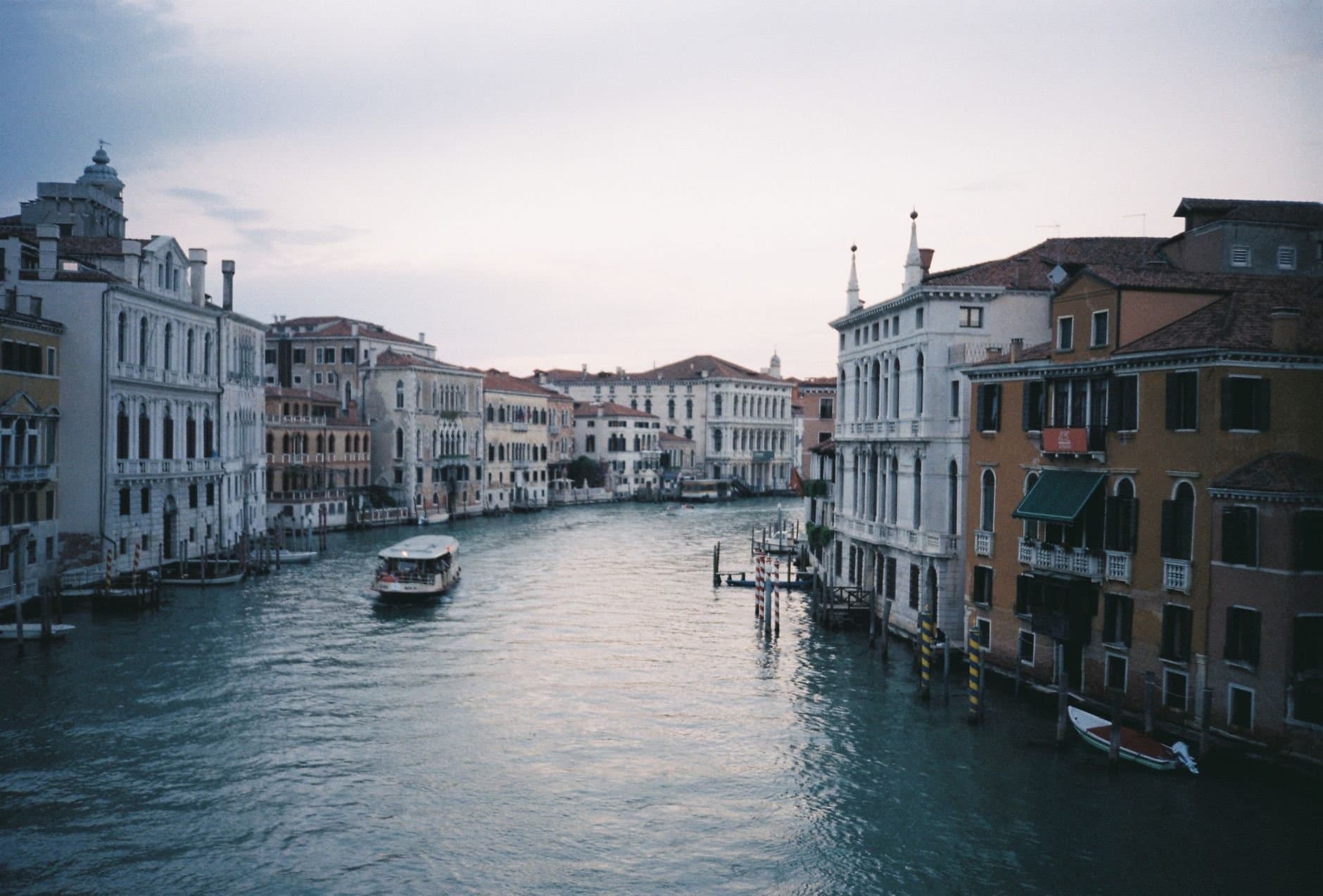Idyllic view of the Grand Canal in Venice with historic buildings and gondola at twilight.