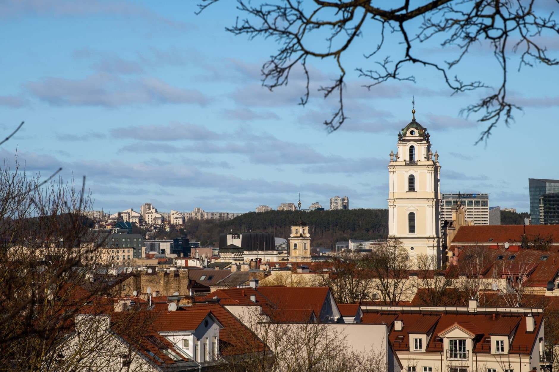 A beautiful view of Vilnius city featuring historic architecture and a prominent church tower under a clear sky.