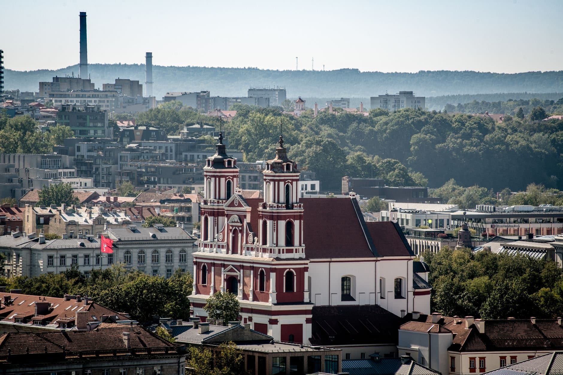 Aerial view of St. Catherine's Church amidst Vilnius cityscape on a sunny day.