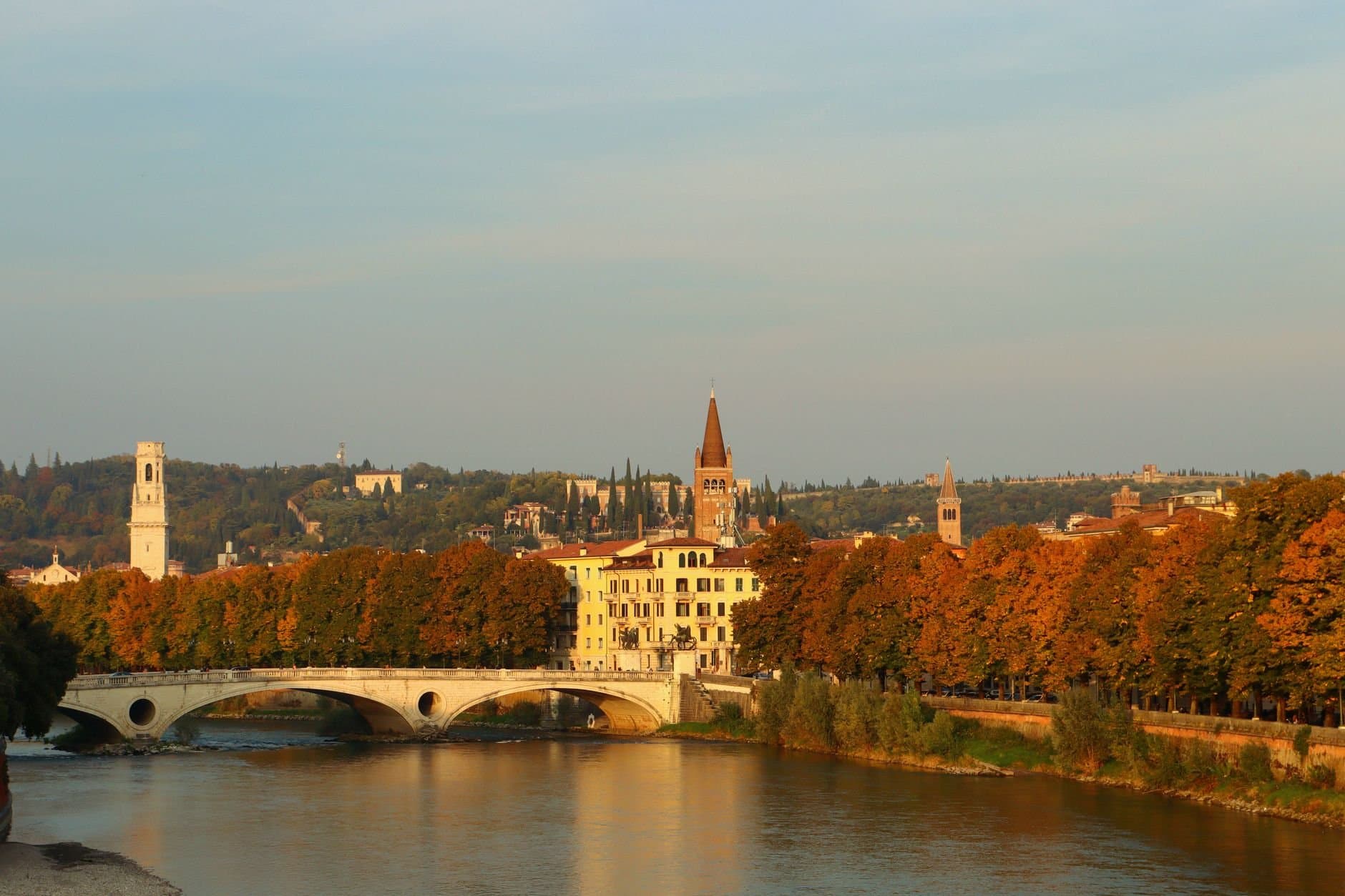 Scenic autumn landscape of Verona, Italy featuring the historic Ponte Pietra bridge.