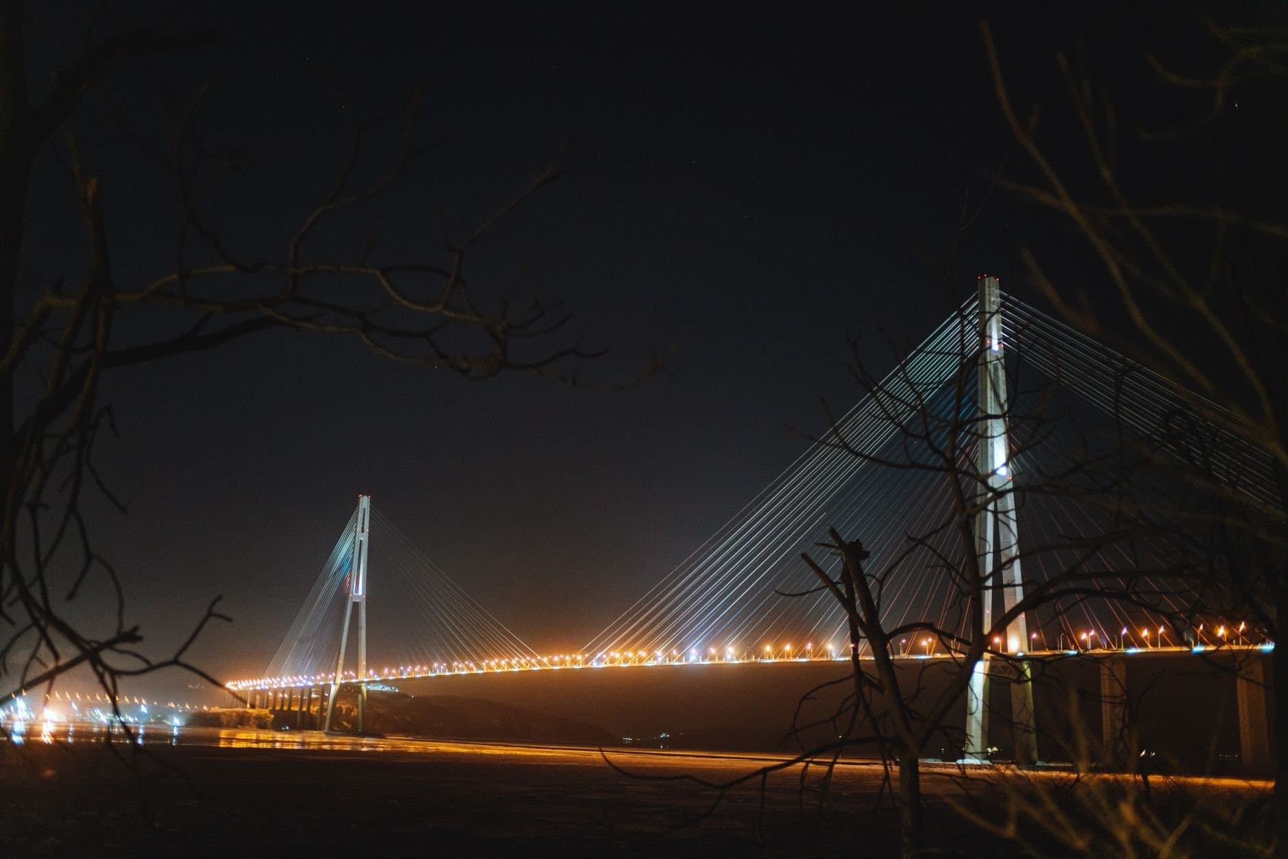 Beautiful night view of the illuminated Russky Bridge, showcasing architectual elegance in Russia.