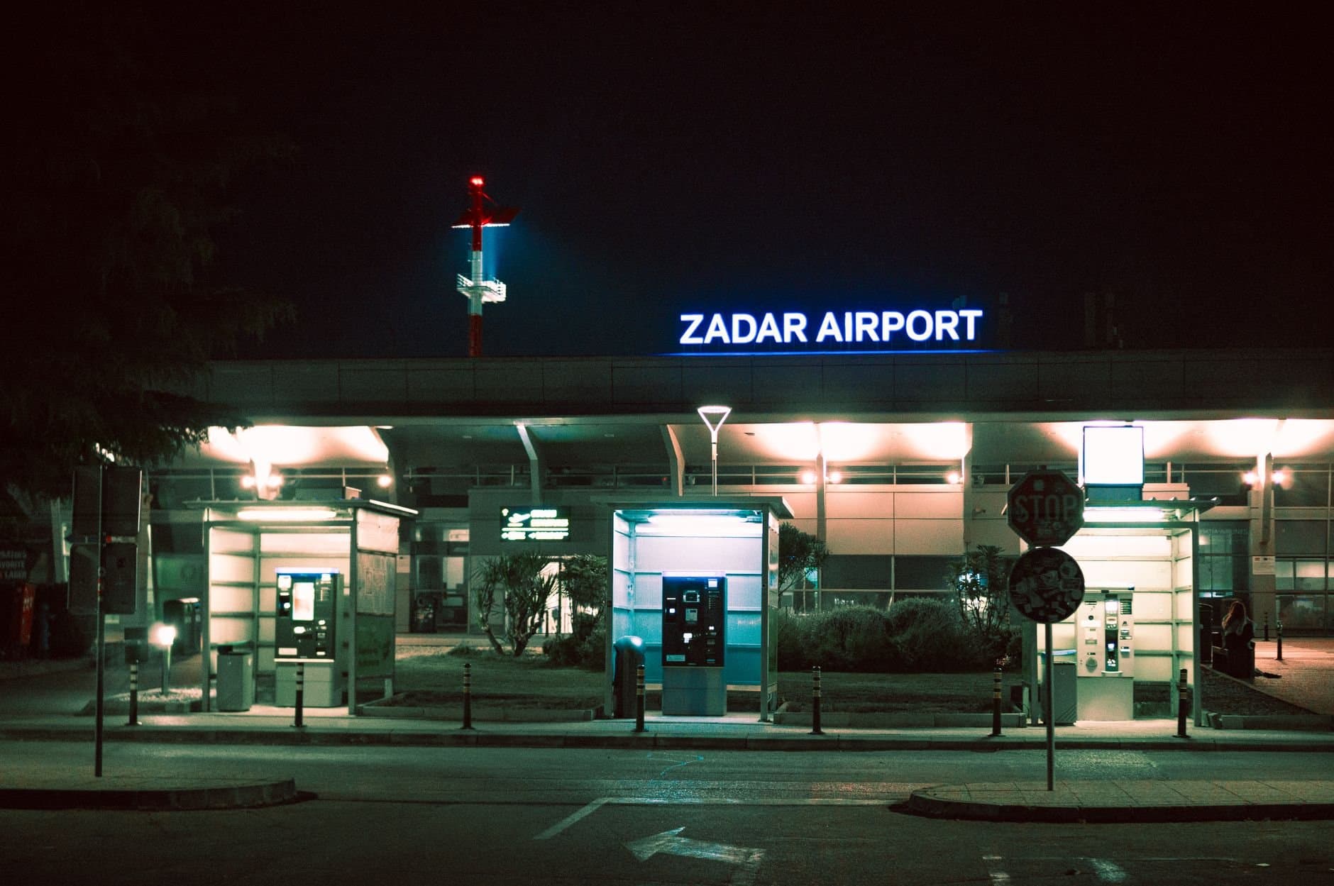 Night view of Zadar Airport entrance in Croatia with vibrant lighting.