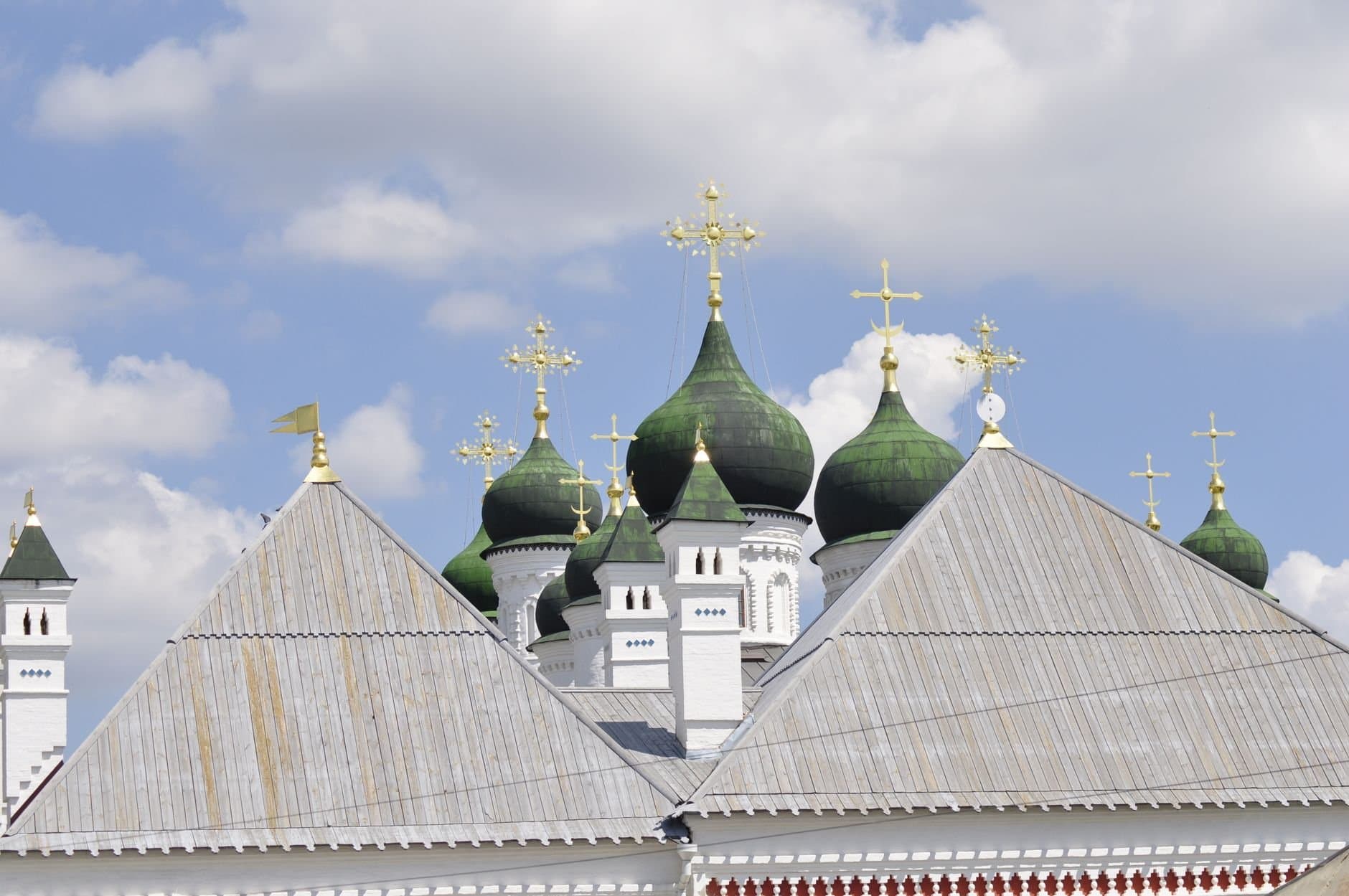 Stunning view of Astrakhan Kremlin's green domes under a bright blue sky.