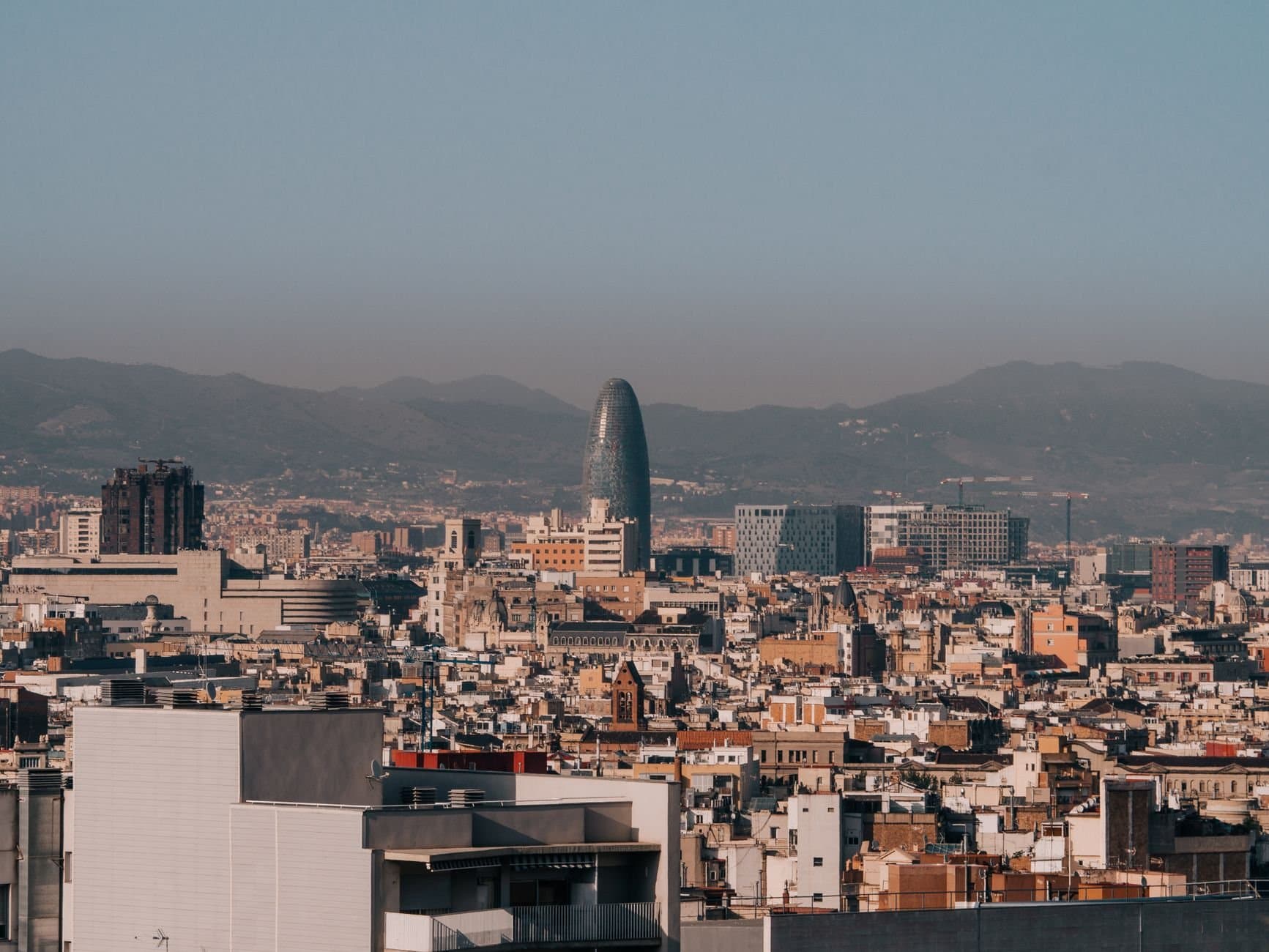 A panoramic view of Barcelona's skyline with Torre Glòries during a clear morning.