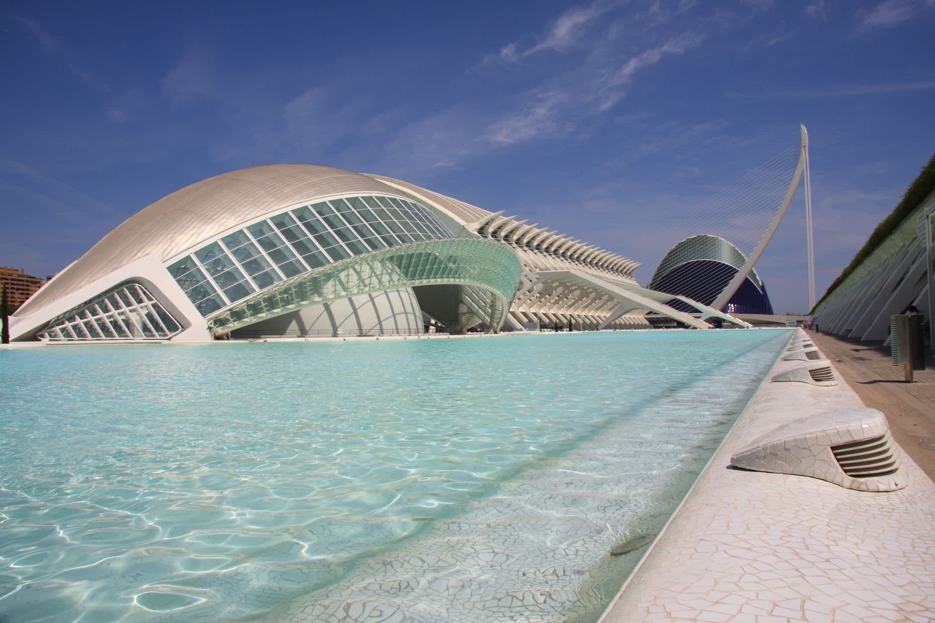Futuristic architecture with poolside view in Valencia showcasing modern design under a clear sky.